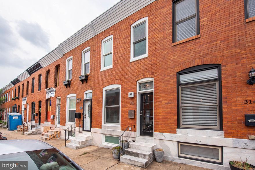 Fantastic, spacious home in a prime location, just 1 block from the beautiful green spaces of Patterson Park, close to shopping, dining, and nightlife, and convenient to I-95 for commuters. This classic brick front home has been impeccably maintained and lovingly updated throughout. Some updates include the kitchen and bath, lighting, roof, water heater, ejector pump, and more. With a large front window & skylights on the upper level, this home is flooded with natural light. It offers the perfect mix & warmth of original charm with exposed brick walls and wood floors combined with modern amenities and updates that cater to today's lifestyle. The open floor plan of the main level includes a large living room, dining room, and remodeled well designed kitchen with light cabinetry, stainless steel appliances, and granite countertops. The kitchen leads to a private, easy to access rear PARKING PAD! The finished lower level includes a large laundry room, ample storage space, and a large finished bonus room/flex space that could be used as a family room/den, 3rd bedroom, at-home office, studio/hobby room, etc. You'll love the smartly designed layout of the upper level that is great for sharing with a roommate or houseguest with two bedrooms and an updated central hall bathroom with deep soaking tub & skylight. Why not have a housemate help pay your mortgage while you build equity? This picture perfect home lives larger than the charming brick front exterior suggests with over 1,300 square feet of finished interior space.