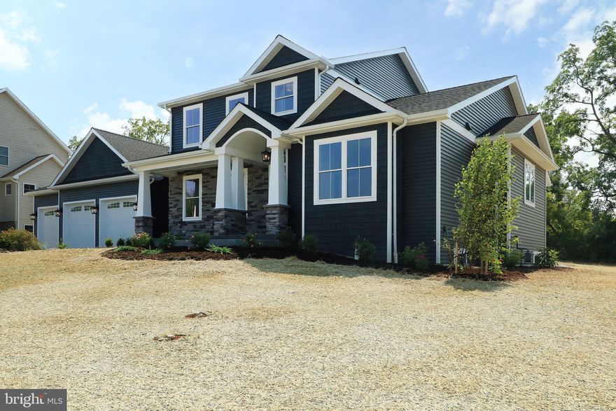 Welcome to 124 Primrose Court in sought-after Stearns Crossing!  Just completed, this custom-built GEM Homes craftsman style home boasts high end finishes, nine foot first floor ceiling height, 5 bedrooms, 4.5 baths, and over 3600+ square feet and features a main floor primary suite.  Enter from the stamped concrete front porch with barrel ceiling into abundant white oak hardwood flooring that flows throughout the main floor, up the stairs & upstairs hallway, and into the 2nd floor secondary suite.  You'll love the plentiful windows throughout and the large sliding doors in the great room letting in an abundance of natural light. The impressive luxury kitchen features custom, handmade solid-wood white mission style cabinetry with upper lighted glass cabinets stretching to the ceiling, a large walnut island with cabinets on both sides and a large breakfast bar, quartz countertops, GE Cafe series stainless steel appliances including a 48" 6 burner gas cooktop with pot-filler, a double oven, a tiled backsplash, undercabinet, pendant, and recessed lighting, and a huge walk-in pantry boasting a mix of custom Amish-made cabinetry, solid shelving, a quartz countertop, and a drawer microwave. The sizable dining room with crown molding, chair rail,  sconce lighting and a butler's pantry with a prep sink and beverage fridge is perfect for entertaining.  The expansive family room with abundant windows and large sliders, recessed lights, a ceiling fan, a gas fireplace with stone hearth & walnut mantle, and built-in cabinets and shelving on both sides is great for relaxing or entertaining.  The main floor primary bedroom boasts two walk-in closets and a beautiful luxury bath with a furniture grade white oak double sink vanity, shiplap accent walls, quartz countertop, metal framed mirrors, a free-standing soaking tub, heated tile flooring, a toilet closet, and a large tiled shower with a frameless glass door, rain shower head, hand-held sprayer, and a bench.  A large first floor office, a half bath, a mudroom with a built-in bench, and a laundry room with a utility sink, custom cabinets, and a quartz countertop complete the main floor.  Upstairs, you'll find a second suite boasting plentiful recessed lights and an ensuite bath with a double sink vanity and a custom tiled shower with a frameless glass door.  Three additional ample-sized bedrooms and two additional full baths with Amish-made cabinetry, quartz countertops, tile floors, and tiled tub surrounds complete the second floor.  The oversized three car garage provides hobby space and a utility sink while the mudroom has a built-in bench with shiplap backing and a large closet.  Upgraded with two separate gas HVAC systems you'll have total control over temperatures on each floor and be comfortable throughout the house.  Downstairs, the unfinished basement has nine foot ceilings, two egress windows, and full bath pre-plumbing for future finishing.  Relax on the front stamped concrete porch, gather on the covered rear stamped concrete patio, or have fun on your half acre flat lot offering privacy with its mature tree line.  Additional features are black bath, door and light fixtures, black metal railing balusters, solid core doors, solid closet shelving, framed bath mirrors, and tiled shower and tub surrounds throughout.  A short walk to Fogleman Fields and Spring Creek Elementary, and not far from Spring Creek Park provide for plenty of recreation.  Conveniently located close to Penn State, Mt. Nittany Medical Center, downtown State College and the mall area, yet tucked away in a quiet part of town. Luxury living at its best!