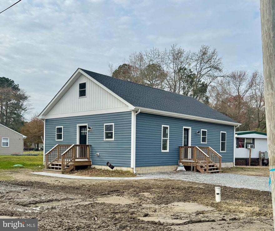 Experience refined living in this beautifully designed new-construction two bedroom, two full bath home, where timeless finishes meet modern comfort in a thoughtfully crafted open floor plan. The stunning great room is designed to seamlessly accommodate both living and dining, highlighted by soaring vaulted ceilings, a dramatic celestial window, and an abundance of natural light. Elegant picture-frame molding, gracefully capped with a chair rail, and subtle ship-lap accent  wall adds architectural sophistication and sets a tone of understated luxury. Flowing effortlessly from the great room, the impeccably appointed kitchen is both beautiful and functional, featuring a striking herringbone backsplash, stainless steel appliances, a show-stopping farmhouse sink, and sleek quartz countertops. Forty-two-inch dove-gray cabinetry, a pantry, and direct access to a utility/mudroom complete this designer-inspired space.
The home’s exquisite molding continues down the main hallway, leading to a versatile bonus room ideal for a home office, creative studio, or hobby space. The serene primary suite offers a walk-in closet and a beautifully finished en-suite bath, while the secondary bedroom is conveniently served by a stylish full hall bath. Luxury vinyl plank flooring and recessed lighting extend throughout the entire home, reinforcing the cohesive, polished aesthetic. Meticulously designed with exceptional attention to detail, this two-bedroom, two-bath residence delivers elevated style, comfort, and functionality, perfect for today’s discerning buyer.