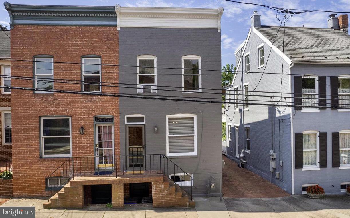Lovely end unit townhome in the Downtown Frederick Historic District. Step out your front door and walk to Market St, the canal, shops, dining and so much more. Two bedrooms and 1.5 baths. You can feel the history in these walls and community. There is a living room with built in bookcases, a separate dining room for entertaining, a generous eat in kitchen waiting for it's chef to create their incredible meals. From the kitchen you can walk to the enclosed sun porch where you can enjoy your first cup of coffee while admiring your private backyard. You will be enjoying the mini splits that provide the air conditioning on those hot days. Upstairs there is a huge walk in closet and the upstairs bath is large with a separate soaking tub and good sized shower. There is off street parking that backs to the MD school for the Deaf, with views of the Hessian Barracks the surround your home with history and beauty. The backyard is completely fenced in for privacy. The full basement has your laundry appliances, storage room plus inside access that allows for front and rear access. All this just steps away from the fun, friendly and lively downtown environment.