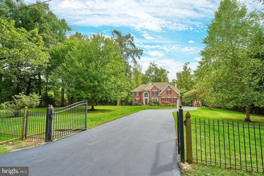 Welcome to this stunning brick home with private security gate and backing right up to the W 0&D walking and biking trail - 10 minutes to downtown Vienna. Updated kitchen and upper level baths 2022. A stately brick-front home with a classic, timeless design, located at the end of a quiet, tree-lined street. The house sits on a sprawling, well-manicured lawn with a wrought iron gate across the driveway, adding an extra layer of security and elegance. In the background, there’s the Washington & Old Dominion Trail, offering a serene nature path with trees and greenery. The sky above could be clear with soft sunlight illuminating the front of the house, highlighting its architectural details. The flooring throughout the home is natural hardwood installed 2022, warm and inviting, extending seamlessly from room to room.
The home office features French doors for privacy, with a modern, professional setup  that creates a peaceful working environment. Moving into the living room, extra large windows allow natural light to flood the space, making it feel bright and airy. 
Next, the dining room is set with a stylish and unique chandelier that hangs above a large table, perfect for family gatherings or dinner parties. Finally, the gourmet kitchen stands out with its high-end stainless steel appliances, a wall oven, cooktop, sleek white cabinets, and recessed lighting that illuminates every corner.  The view showcases a beautiful and oversized Trex deck extending from the back of the house, overlooking a lush, expansive 1-acre lot. The deck has space for outdoor furniture and a grill (natural gas line to grill and outdoor firepit), perfect for enjoying the outdoors. Beyond the deck, you can see mature shrubs and trees creating a natural privacy screen, offering both beauty and seclusion.  The main level laundry room, which is modern and functional, featuring sleek cabinets for storage and a washer and dryer, all conveniently arranged to make wash day easy for new homeowners. Next, we'll transition to the upper level, where the focal point is the primary suite. It features a spacious bedroom with two walk-in closets and a large primary bathroom. This bathroom is luxurious, with a walk-in shower adorned with porcelain tiles, an elegant freestanding bathtub, and a double vanity with plenty of counter space.
Included are the other three bedrooms, each with large windows that let in natural light, oversized closets, and ceiling fans for comfort. All painted in designer neutral colors.  Walk down to the lower level to discover more beautiful Hardwood flooring.  Enjoy gatherings in the spacious Rec Room, bright with recessed lighting.  The Wet Bar is perfect for your wine tasting events and entertaining.  The large Work Out room will be where everyone can quietly spend time getting into shape!  Plus the 4th Full Bathroom will be used by any of your quests or residents.  Oversized storage room too!   Freshly sealed driveway, New attic heat pump 2023, New Hardwoods 2022,  New hot water heater 2022.