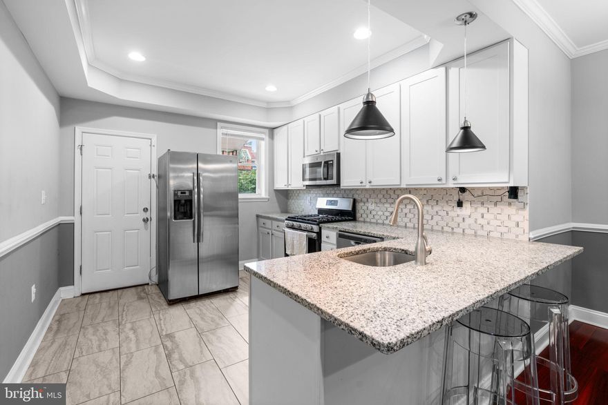 Charming townhouse offering 1,184 square feet of living space with 3 bedrooms and 2 full bathrooms, perfectly situated in vibrant Greek Town. A welcoming front porch and a patio with a garden set the tone as you step inside the open-concept main level, featuring gleaming floors and an elegant chair railing. The spacious living room flows seamlessly into the dining area, enhanced by a stylish chandelier. Just beyond, the gorgeous eat-in kitchen boasts a tray ceiling, stainless steel appliances, a tasteful backsplash, a breakfast bar, and access to a rear porch and a fenced private parking pad that accommodates two cars. Upstairs, three comfortable carpeted bedrooms and a full bathroom provide relaxing retreats. The finished lower level offers additional versatile space ideal for a lounge, recreation area, or home office, complete with a second full bathroom and a laundry room.