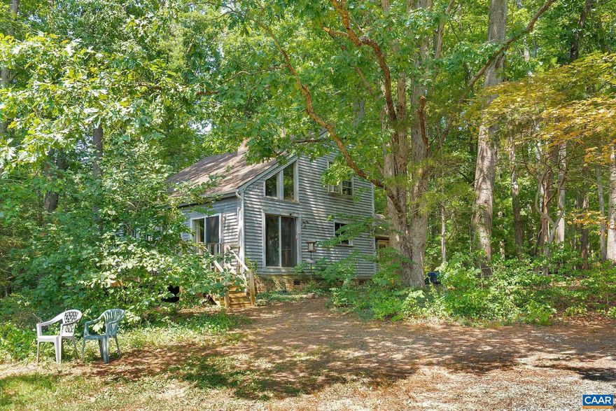 This unique home and the lot it sits on are full of potential sitting on just over six private acres in Earlysville yet roughly only ten minutes from the Hollymead Town Center with Target, grocery, restaurants and coffee. The lot features a level cleared area with sunny garden spot plus several wooded acres. The rustic home features an open plan with a two story great room surrounding a wood burning stove with brick concave backing. Upstairs are two open rooms and a full bath. The main level also features a bedroom with en-suite full bath. The possibilities are endless and might include living in the home as-is, renovating the existing house, or building a new home on the lot.,Fireplace in Great Room