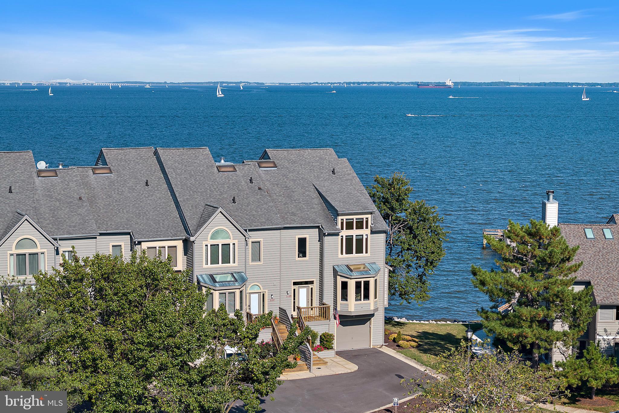 This spectacular end-unit townhome in the gated waterfront community of Chesapeake Harbour offers stunning panoramic views of the Chesapeake Bay and Bay Bridge. With 3,082 sq. ft. across four finished levels and a private elevator, this residence blends luxury, comfort, and convenience.
Highlights include a wraparound main-level deck perfect for entertaining, a living room with fireplace and custom built-ins, and a gourmet kitchen with SubZero refrigerator, GE double ovens, granite and Corian countertops, and skylights. The primary suite boasts a private deck with breathtaking Bay views, three closets, and a new (2024) spa-inspired bath with custom cabinetry, soaking tub, and walk-in shower. The loft level offers unmatched views of the Bay along with a full bath, while the finished lower level provides a wet bar, full bath, workshop, and access to a one-car garage with storage plus parking for two additional vehicles.
Major updates include lower-level HVAC (2022), 80-gallon water heater (2021), freshly painted interiors (2025), and multiple window/door replacements.
The community of Chesapeake Harbour offers an incredible array of amenities including: gated and guarded security, professional management, two community pools (one with bay views), tennis courts, walking trails, beaches, a jetty pier, marina, community grills and public waterfront restaurant. Condo and HOA takes care of landscaping, trash/snow removal, Comcast, and flood insurance. HOA maintains siding, decks, roof (replacement scheduled for 2026), gutters, and annual fireplace/termite inspections.
Enjoy resort-style living with stunning water views just minutes from Downtown Annapolis in one of the most desirable waterfront communities.