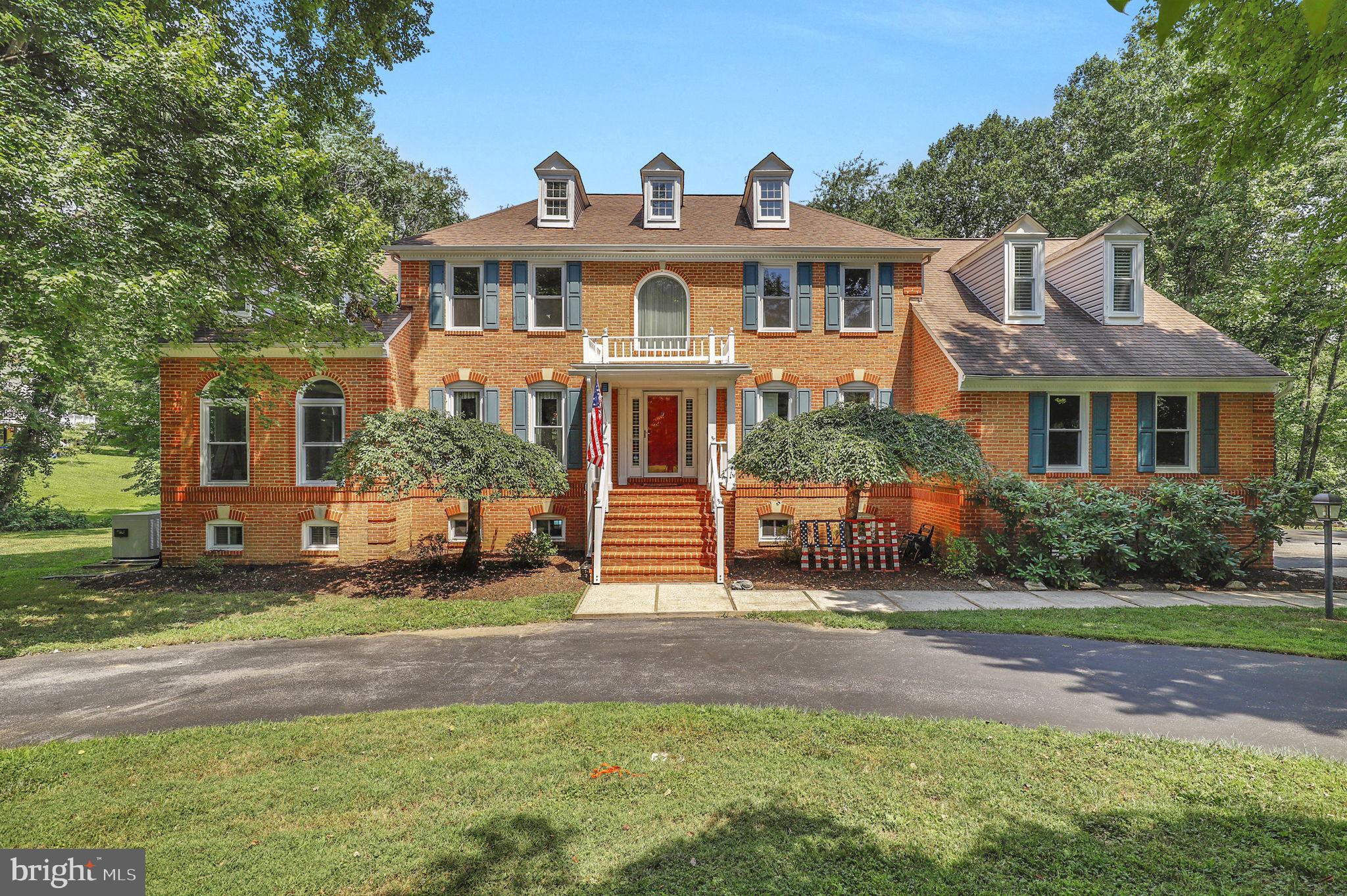 Welcome to this stunning 4-bedroom, 4.5-bath colonial, nestled on 2.42 private acres with a sparkling inground pool and two decks for outdoor living. A two-story foyer greets you, flanked by a private office with built-ins and a formal living room that flows into the sun-drenched conservatory with access to a private deck overlooking the pool. The formal dining room is perfect for special gatherings. At the same time, the chic, modern kitchen offers an island, coffee bar, and casual dining space open to the family room with soaring ceilings, skylights, and a cozy wood-burning fireplace. Freshly refinished hardwood floors flow through the kitchen, living, and dining rooms, while new carpet adds comfort to the family room and conservatory. Step onto the large composite deck from the kitchen with stairs leading down to the pool and backyard oasis. Upstairs, the spacious primary suite with a sitting room and spa-like bath is a serene retreat. Brand-new carpet runs throughout the bedrooms, hall, and stairs, giving the entire upper level a fresh, inviting feel. A second bedroom with a private full bath is ideal for guests, while two additional bedrooms share a hall bath, providing comfortable space for everyone. The expansive walkout lower level is designed for entertaining and relaxation. A full kitchen with durable luxury vinyl plank flooring opens directly to the pool area, making summer entertaining a breeze. This level also includes a carpeted living area, a bonus room with an adjoining sauna, a full bathroom, a laundry area, and abundant storage space. Significant updates include triple-pane high-efficiency windows (2019), new vinyl siding (2023), three HVAC units (two heat pumps in 2020 and gas furnace in 2019), a new pressure tank (2018), a whole-house generator, and extensive pool updates, including filters, vacuum, and winter cover and retractable solar cover for summer. This home offers the perfect blend of privacy, comfort, and resort-style living—all with a circular driveway, 2-car garage, carport, and private backyard retreat.