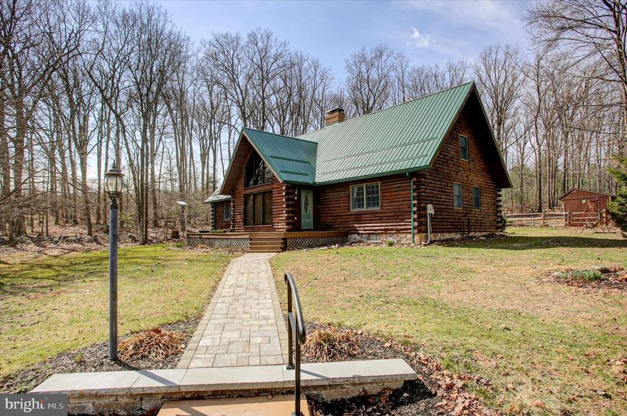 Nestled on 23 breathtaking acres, this stunning log home offers the ultimate in peace, privacy, and natural beauty. As you arrive, you’re greeted by complete silence—an immediate sense of calm that sets this property apart.  Surrounded by  Michaux State Forest and bordering property which is owned by the Waynesboro Borough Authority.  The main level features three comfortable bedrooms and a welcoming living room with soaring ceilings that open to the expansive second floor, creating a bright and airy gathering space. A fourth bedroom is located on the upper level, ideal for guests or a private retreat.
Step outside to enjoy resort-style amenities including a heated pool, relaxing hot tub, and a large deck perfect for entertaining or simply soaking in the tranquil surroundings. The basement provides abundant storage along with a laundry room and convenient second kitchenette, adding flexibility for extended stays or multi-use living. Whether you’re seeking a private getaway, full-time residence, or exceptional retreat property, this one-of-a-kind log home delivers serenity, space, and timeless charm.