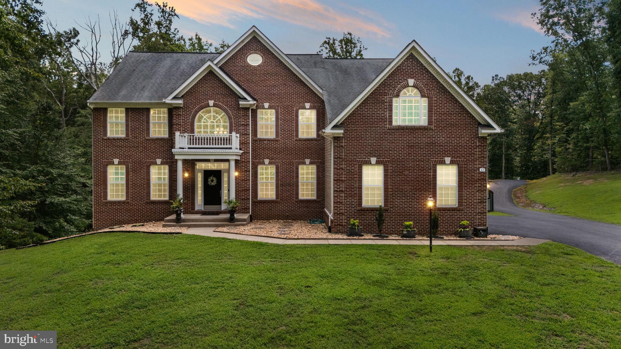 Tucked back from Brooke Crest Lane, this beautifully maintained brick colonial offers a rare blend of peaceful seclusion and everyday accessibility. Set on a total of 3.42 acres surrounded by mature trees, this 4-bedroom, 4.5-bathroom home is accessed via a thoughtfully widened and extended private paved driveway. With over 5,700 square feet of living space, the property reflects intentional design and quality craftsmanship throughout.
The interior features an open floor plan designed for both comfort and functionality. The spacious gourmet kitchen is equipped with stainless steel appliances, granite countertops, a double oven, and a butler’s pantry, flowing into a family room with a gas fireplace and striking atrium windows. A formal dining room, formal living room, office/den, main-level laundry, and hardwood floors complete the main level.
The entryway showcases a front spiral staircase as a stunning focal point, complemented by a second staircase leading to the upper landing. Upstairs, the primary suite offers a true retreat with two walk-in closets and a spacious ensuite bathroom, along with additional bedrooms thoughtfully arranged for privacy and convenience.
The lower level provides versatile bonus rooms that can easily be customized as a home theater, game room, exercise space, hobby room, in-law suite, or additional storage.
Garage space is a standout feature, with parking for up to 10 vehicles in total. The attached garage accommodates 3 cars and includes a Level 2 electric vehicle charging station. The impressive detached garage accommodates up to 7 vehicles, offering over 1,400 square feet of additional space. The detached garage includes a total of 80 AMP service, featuring a dedicated 50 AMP connection specifically for recreational vehicles or equipment. It also includes a water line for added functionality, making it ideal for oversized vehicles, workshop needs, or extra storage.
A dual-zone heating and cooling system ensures year-round comfort and efficiency, complemented by a whole-home air purification system designed to remove impurities from the air, including bacteria. added peace of mind and efficiency, the home is equipped with a highly efficient wood boiler unit that serves as a backup heating source. The wood boiler is approximately 90% EPA compliant, offering both sustainability and reliability. A whole-house built-in generator conveys with the property, powering both the main residence and the detached garage.
Despite its tranquil, secluded setting, this home is located just approximately 10 minutes from Brooke VRE station, commuter lots, and I-95. Outdoor enthusiasts will appreciate the proximity to Crow’s Nest Natural Preserve, Government Island, Curtis Memorial Park, and Aquia Park, all offering hiking, kayaking, fishing, and more.
This move-in-ready property truly blends luxury, privacy, and thoughtful design throughout every living space.