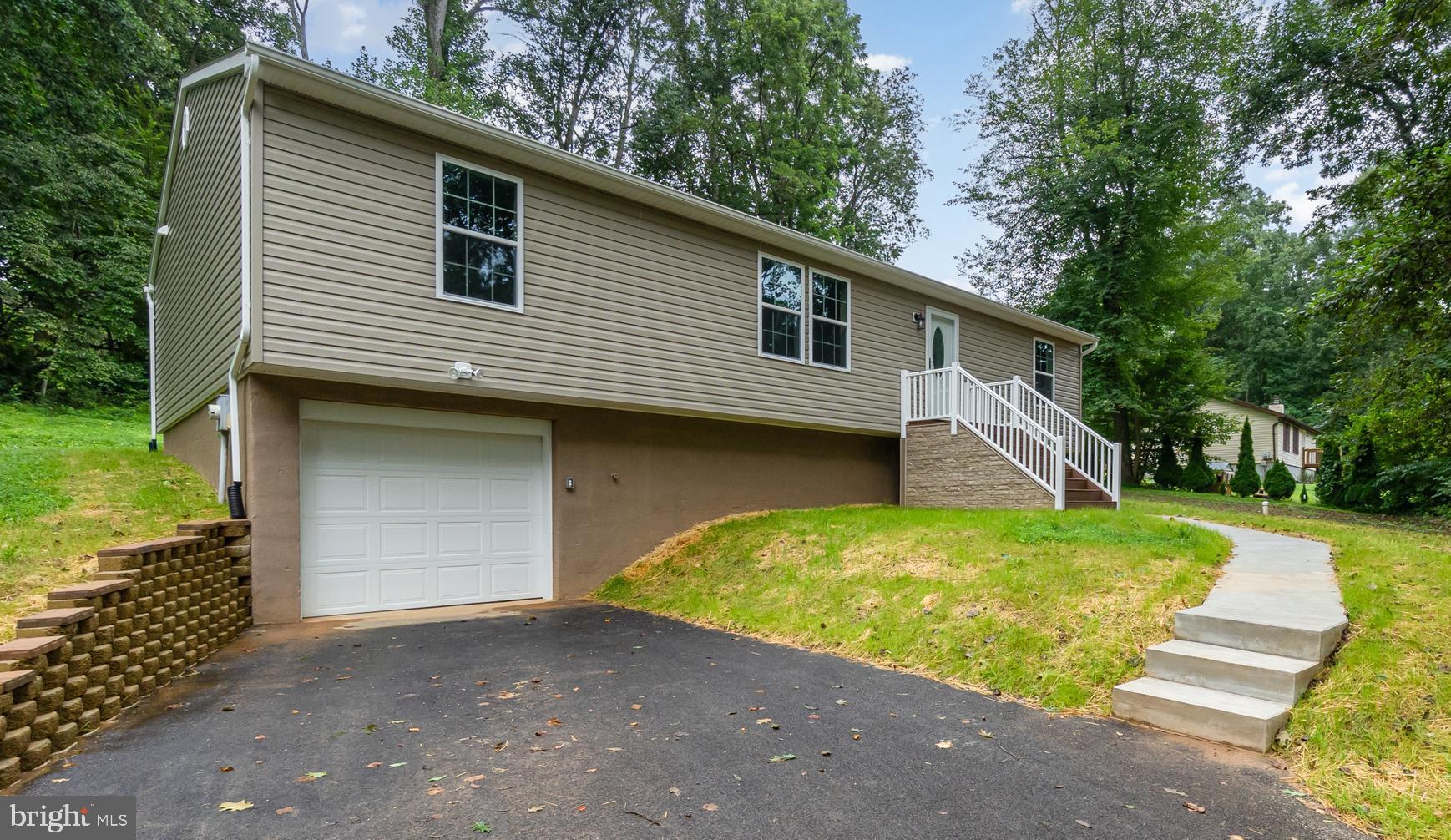 Welcome to this beautifully updated home where everything is brand new! Offering modern finishes and a functional layout in the peaceful Octoraro Lakes community of Rising Sun. Nestled among beautiful wooded scenery and close to the sounds of Octoraro Creek, this home provides a tranquil retreat while still being just minutes from shopping. The main level features an open-concept kitchen with stainless steel appliances, and a spacious island overlooking the dining area and living space—perfect for entertaining. Natural light fills the home through large windows, highlighting the neutral tones and stylish flooring throughout. The primary suite is generously sized with ample closet space, and the bathrooms are tastefully designed with double vanities and contemporary fixtures. Two additional spacious bedrooms and laundry room complete the main level. The partially finished lower level includes a large entertainment area, bonus room perfect for a home office, or gym, and direct access to the garage. Enjoy outdoor living with a back deck and a private, tree-lined yard. The scenic community features two lakes perfect for fishing and pavilion for gatherings. With a paved driveway, garage, and low-maintenance exterior, this home combines convenience, comfort, and a wonderful neighborhood setting.