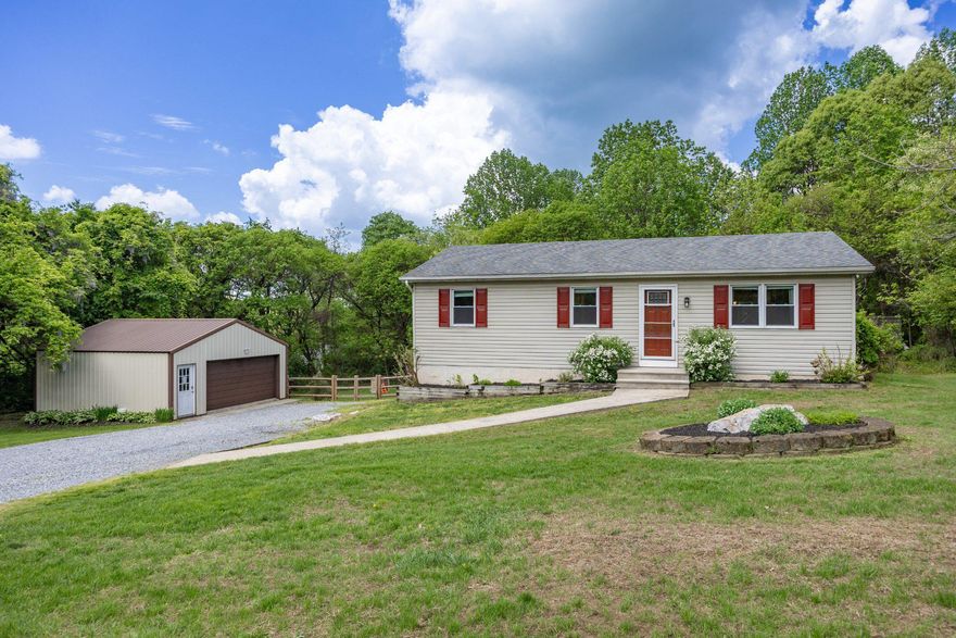 Discover the charm of this beautifully updated ranch home, situated on a serene 0.98-acre lot backing to lush trees for the perfect blend of privacy, peace, and natural beauty. Built in 1997, this detached gem offers three bedrooms, one full bathroom, a cozy living and dining space paired with a recently updated kitchen. Newer luxury vinyl plank flooring (2020) flows throughout the main living areas, while ceiling fans in every room and central A/C provide year-round comfort. Step outside to the expansive rear deck — an ideal space for relaxing, entertaining, or simply enjoying the scenic wooded backdrop. The partially finished walkout basement, renovated in 2023, adds valuable additional living space complete with epoxy floors, recessed lighting, a built-in wet bar, propane faux wood stove, laundry area, extra storage, and direct access to the backyard. Portable Craftsman 5600 Watt generator is also included for added peace of mind. With abundant parking, an oversized detached two-car garage, and a spacious fenced yard, this property offers true privacy in a quiet, rural setting. Don’t miss your opportunity to call it home!