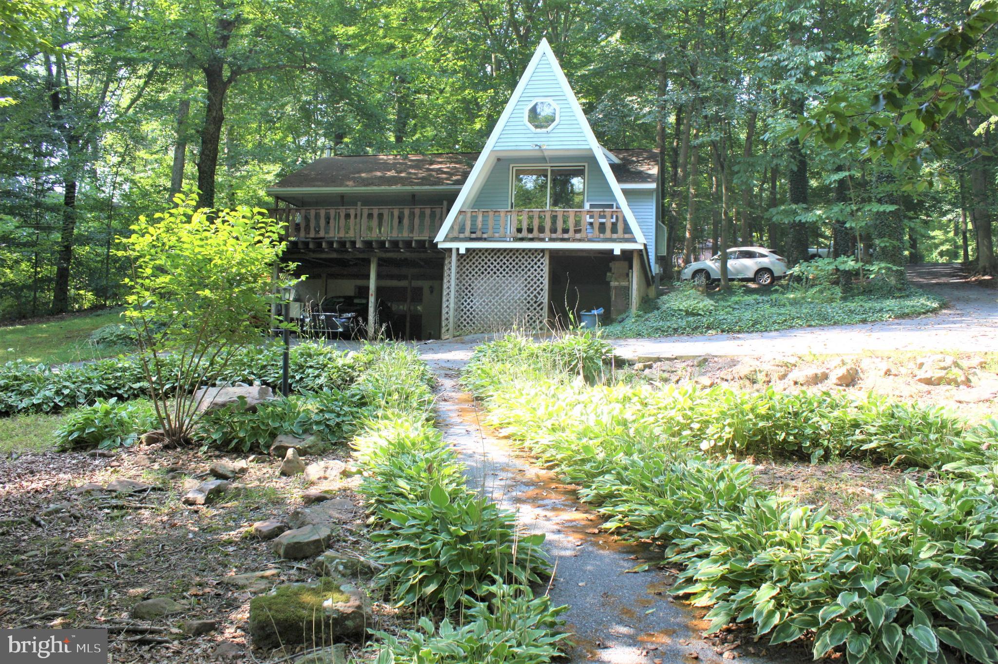 THIS PROPERTY IS GOING TO AUCTION ON FRIDAY OCTOBER 1, 2021 @ 5:30 pm. THE LIST PRICE ONLY RELFECTS THE STARTING BID. THIS PROPERTY NEEDS TO BE SOLD AT THE LIVE ON-SITE AUCTION. ANY OFFERS BEFORE OCTOBER 1 WILL BE CONSIDERED A STARTING BID. Wonderful forested setting, backyard leads to a peaceful small stream ("Middle Creek")! Charming A-from style house w/2 BR situated on a 1.1 acre secluded lot. Main level features an eat-in kitchen w/wooden cabinetry, great room w/fireplace and patio doors leading to a small deck, primary BR w/WIC and private BA. The second BR is located in the A-frame loft. Lower level offers a 1-car garage and work shop. 22' x 19' treated wood deck, parking under the deck, central vac, circle driveway, small storage shed. House could use some updating.