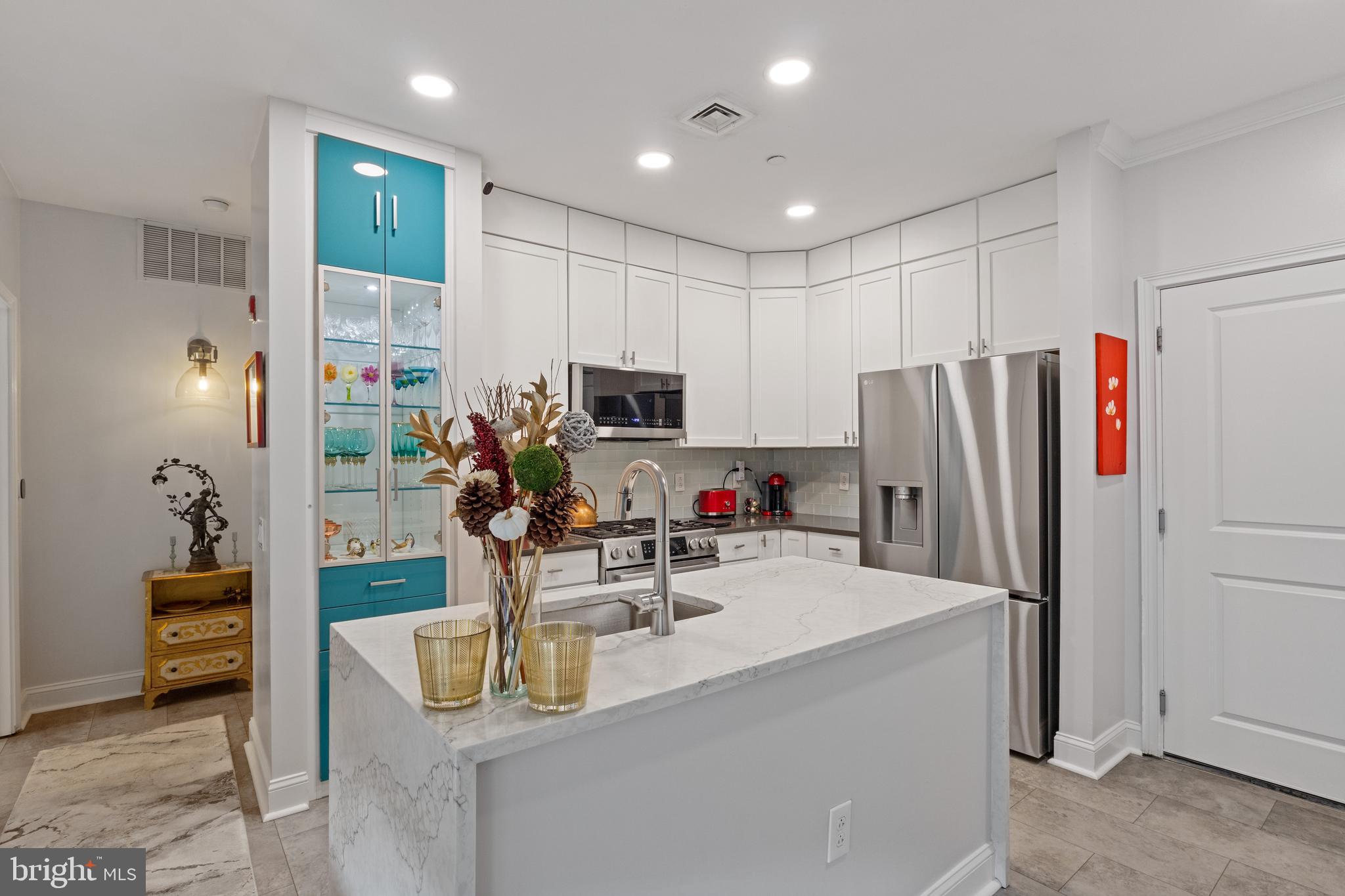 This beautifully modern and updated 2-bedroom, 1-bathroom condo offers modern elegance with an open-concept layout.. The bright living and dining areas lead to a private balcony, perfect for relaxation. The stylish kitchen features white cabinetry, quartz countertops, stainless steel appliances, a striking built-in glass display cabinet and an island with a waterfall countertop. The spacious primary bedroom offers a walk in closet, while the second bedroom is ideal for guests or a home office. The spa-like bathroom boasts sleek black tile, a soaking tub, and modern finishes. Parking spot #225 included and a prime location.
Enjoy Naval Square’s top-tier amenities, including 24-hour gated security, concierge service, a state-of-the-art fitness center, a heated outdoor pool, a sundeck, a common room, manicured gardens, picnic areas, and guest parking. Situated on a lush 20-acre, park-like setting, this pet-friendly residence is just a short distance from fine dining, boutique shopping, and world-renowned cultural destinations. Drexel, CHOP, Penn, University City, the Schuylkill River Trail, and Rittenhouse Square are all a short walk away.
This home offers the perfect blend of city convenience and private community living. Don’t miss this incredible opportunity—schedule your tour today!