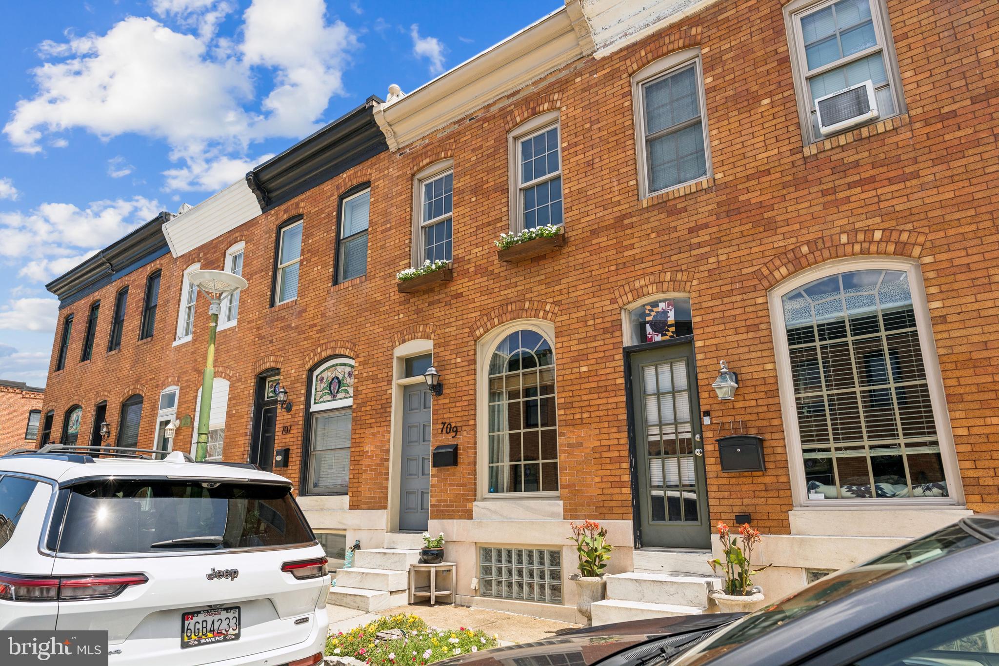 You won’t be able to resist this gorgeous, move-in ready rowhome on one of the most sought-after blocks in the heart of Canton—with parking out back! The expansive living room features gleaming hardwood floors, an exposed brick wall, a sunny picture window, and crown molding. Just beyond, the inviting dining area includes a new light fixture and is perfect for entertaining. The stunning kitchen offers quartz countertops, stainless steel appliances (new fridge 2024), ample solid wood cabinetry, gas cooking, built-in shelving, and an oversized pantry. A designated entrance to the rear parking pad is located just off the kitchen. Upstairs, you'll find a spacious primary bedroom with soaring beamed ceilings, an exposed brick wall, new light fixtures, and two bright windows. The generously sized second bedroom includes access to a charming private deck. The recently renovated full bath features built-in shelving and a spa-like jetted soaking tub. The finished lower level includes a large carpeted family room and a spacious laundry/storage room with an additional exterior storage area. Recent updates include: new light fixtures throughout, a fully renovated bathroom, a new water heater (2024), a new fridge (2024) and more. Enjoy close proximity to retail shopping, local dining, Patterson Park, and major highways. Schedule your private tour today!