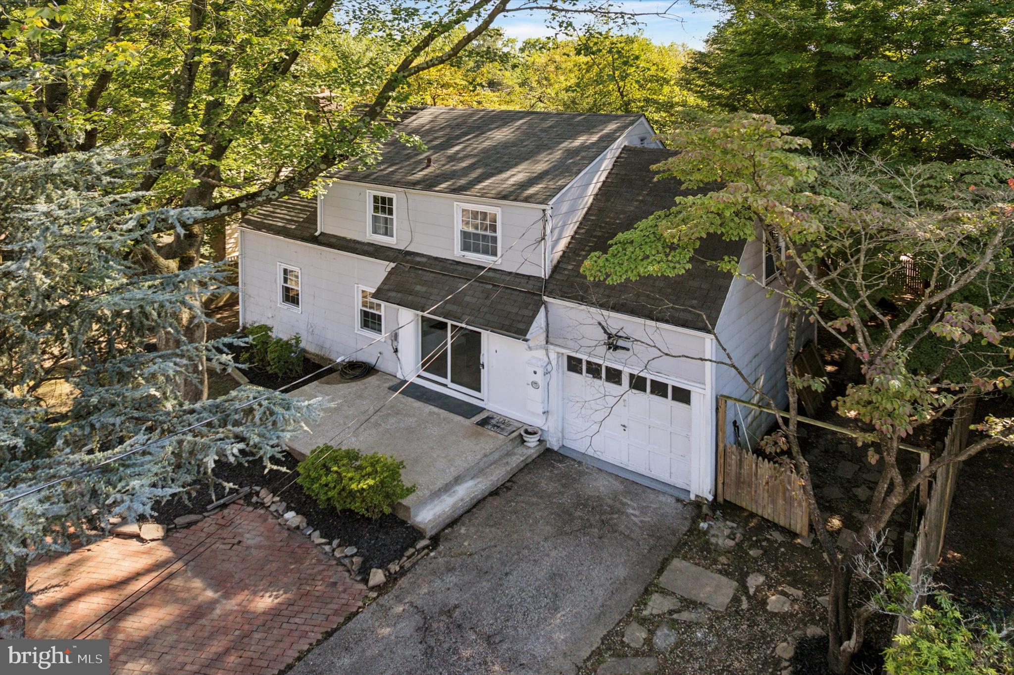 Imagine coming home to a beautifully maintained 3-bedroom, 1.5-bathroom Cape Cod style home tucked on nearly a quarter-acre lot along a private, serene drive—rare find at this price point in the Lower Merion school district. The main level flows effortlessly with a living room and dining room perfect for entertaining with a first floor powder room and a tasteful kitchen with maple cabinetry, granite counters, stainless steel appliances, and a sophisticated tile backsplash. The crown jewel of this historic home is the massive sun-drenched sunroom in the rear of the house featuring vaulted ceilings, a wood-burning stove, and a wall of windows overlooking the fully fenced yard, creating the perfect backdrop for morning coffee or al fresco dinners. Upstairs, the primary bedroom boasts a walk-in closet, while the second bedroom connects to a bonus room ideal for a home office or nursery, all serviced by a full hallway bathroom. The partially finished basement with tile floors and recessed lighting offers flexible space for a media room, playroom, or home gym alongside a large, unfinished workshop with an in-home laundry area. Additional highlights include original, small-plank hardwood flooring throughout, a single car attached garage, private gated driveway for two additional parking spaces and meticulously maintained fenced grounds. Located within walking distance to Wynnewood Valley Park and Penn Wynne Elementary School, this move-in ready home combines historic charm with modern convenience—an exceptional opportunity for step-up homebuyers seeking a residence with parking, ample living space/storage and a coveted Lower Merion address. Homes like this, in a premier location with turnkey condition and ample parking plus plentiful outdoor space, are truly hard to come by—don’t miss your chance to make it your own. Schedule your showing today, before it’s too late. Some photos are AI enhanced.
