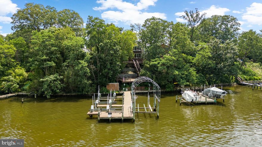 Beautifully remodeled, this stunning waterfront Colonial in sought-after Green Haven offers direct navigable access to Stoney Creek and breathtaking views from nearly every level. Tucked along the shoreline, the home presents an exceptional opportunity for water lovers with private multiple-slip docking and an inviting outdoor setting that embraces relaxation.

The home makes a striking first impression with a large front driveway, manicured landscaping, and gorgeous curb appeal enhanced by stone accents. Inside, the light-filled living room features rich hardwood flooring and a cozy pellet stove. The eat-in kitchen is both vibrant and functional, showcasing blue cabinetry, granite countertops, a stone backsplash, stainless steel appliances, a pantry, and an island with bar seating. A cozy breakfast nook opens seamlessly into the spacious family room, where an accent wall, expansive sliding glass doors, a convenient powder room, and sweeping water views create a truly special space. Also on the main level is a bedroom with a full bathroom nearby, ideal for guests or multigenerational living.

Upstairs, the luxurious primary suite is a true retreat, featuring soaring cathedral ceilings, dual ceiling fans, a stacked stone gas fireplace, and a private balcony with water views. The en suite bath includes a corner jetted soaking tub, a separate glass-enclosed shower, a dual-sink vanity, a skylight, and dual access from the hallway for added convenience. A custom walk-in closet with built-in organization completes the suite. An additional spacious bedroom and a laundry area in the hallway round out the upper level. The fully finished lower level adds even more flexible living space, including a large recreation room with luxury vinyl tile flooring, an accent wall, and walk-out access to the exterior. There's also a sitting/foyer with a full bathroom and a bonus room with its own walk-out access—ideal as an office, studio, or guest space.

Step outside to discover the ultimate waterfront lifestyle. A tiered deck with a pergola and built-in bar area offers the perfect setting for entertaining, while a side patio wraps around to the front driveway. Beautifully maintained decking and retaining walls thoughtfully constructed in 2022, enhance both the aesthetics and function of the outdoor space. Follow the steps to the lower deck and private dock, complete with multiple boat slips. With deep water access—measuring approximately 8 feet at low tide from the top of the pier—even large boats can easily navigate the waterways right to the property, offering seamless access to Stoney Creek and the open water beyond.