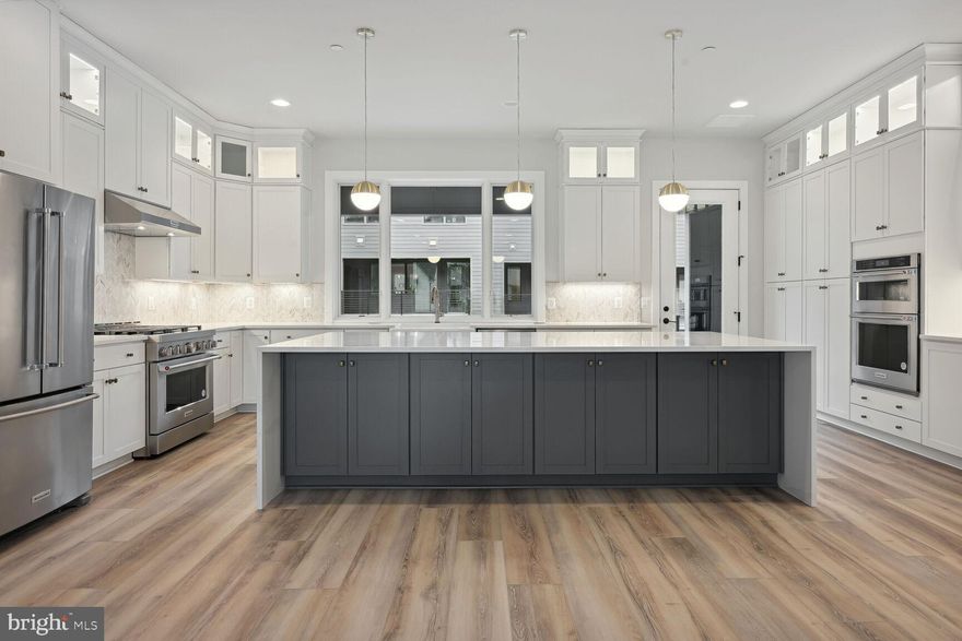 The bright and airy main living level offers a light-filled great room, a spacious dining room, and a large rear kitchen that opens to the outdoor living space. The Chef’s dream kitchen is complete with upgraded white cabinets with glass upper cabinets, Calacatta Gold quartz countertops, champagne bronze hardware and kitchen faucet, under cabinet lighting, KitchenAid stainless steel appliances, and an enormous waterfall island that is accented with Greyhound cabinets. Upstairs you’ll find a luxurious primary suite with huge walk-in closet and an upgraded primary bath with Ariel quartz countertops, frameless shower doors, and champagne bronze hardware and fixtures. The second level also has two large secondary bedrooms and a conveniently located laundry room. The lower level has a large open rec room and an additional full bath. Never again will there be such a grand urban enclave in Bethesda, featuring elegant townhomes beyond your wildest aspirations. Full of premier amenities and distinguished by magnificent trails, Amalyn is a discerning community providing life without limitations.