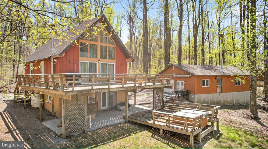 Welcome to 253 Tomahawk Way – a charming, character-filled A-frame retreat boasting 1,500+ SQFT. situated on just over 2 acres in the beautiful community of Blue Mountain,  Linden, VA.

Step inside to a bright main living space featuring soaring ceilings and expansive windows that flood the home with natural light. The main level offers a seamless flow between the living and kitchen area + two comfortable bedrooms, a full bathroom, and a spacious loft—perfect as an additional living area, office, or guest space.

Enjoy multi-level outdoor living with decks accessible from both the main level and the walkout basement—ideal for relaxing or entertaining. The finished basement includes another nicely sized family room complete with a wet bar, a second full bath, laundry area, and plenty of room to unwind or host guests.

Outside, you’ll find a detached oversized garage with ample space for a workshop, plus a built-in bar area —making it the perfect spot for weekend gatherings or DIY projects. Two additional sheds convey with the property, providing plenty of covered storage for tools, equipment, or recreational gear.

The property features a nicely sized concrete patio in the back, and hot-tub deck! So don't miss your opportunity! Whether you're looking for a full-time residence or a weekend getaway, this unique mountain home offers comfort, functionality, and privacy—all within a 20 minute drive to major shopping, dining, schools, hospitals and more! Sold as-is where-is.
