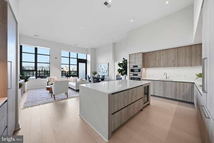 An Extraordinary Indoor–Outdoor Residence at MUSE

Unit 105 offers something truly rare in luxury condominium living: seamless, private access to the outdoors directly from your own 200-square-foot terrace. Step outside to the Mount Vernon Trail and waterfront just beyond — morning rides, sunset strolls, and fresh air are quite literally at your doorstep.

Inside, soaring 13-foot ceilings and dramatic walls of floor-to-ceiling glass flood the home with natural light, creating an airy, gallery-like ambiance. The open-concept design is both refined and intentional, maximizing every inch with clean architectural lines, 7.5-inch-wide hardwood flooring, and recessed lighting.

The chef’s kitchen is a study in modern European elegance, featuring panelized Thermador appliances, quartz countertops, an expansive island, integrated wine refrigeration, and sleek custom Snaidero Italian cabinetry. Designed for both entertaining and everyday living, it offers abundant storage including a generous pantry and extensive cabinetry.

The baths evoke a private spa retreat, appointed with Waterworks fixtures, Calacatta porcelain tile, and custom Snaidero vanities in a serene, neutral palette. A spacious laundry room, linen closet, and thoughtfully integrated storage ensure effortless living without compromise.

Adding to the rarity and convenience of this offering are two secured garage parking spaces and a private storage unit— a highly coveted combination that elevates both practicality and long-term value.

Life at MUSE is equally exceptional. Residents enjoy white-glove service with a 24-hour concierge, daytime porter, and on-site management and engineering. The rooftop clubroom captures sweeping views of the DC monuments, the Potomac River, and Old Town skyline, flowing seamlessly to expansive terraces with fireplaces, grilling stations, and refined lounge spaces. A penthouse-level fitness and yoga studio — complete with outdoor training terrace — delivers state-of-the-art wellness at home.

Perfectly positioned in North Old Town’s emerging Arts District in Alexandria, with immediate access to the Mount Vernon Trail and just moments from DC, this residence offers a lifestyle defined by connection — to light, to air, to water, and to the city beyond.

This is condominium living reimagined.