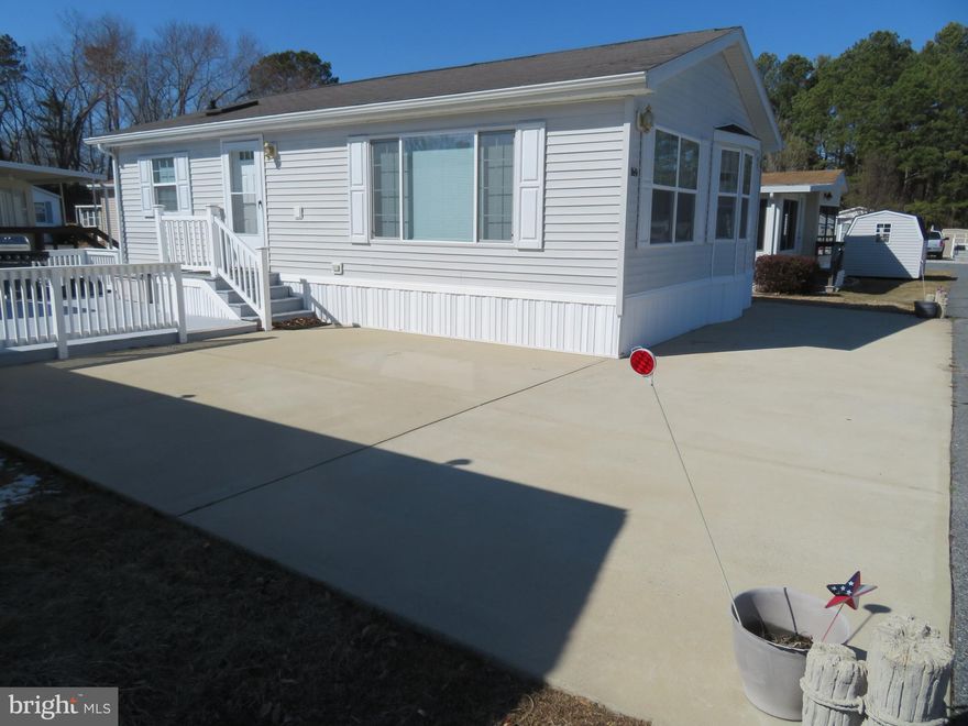So many recent upgrades and so many amenities at this very lightly used MANORWOOD MODULAR 2001 built 2nd home to owners. Has not been a rental & well cared for. TURN KEY & can be 2nd home, investment or rental with some rental restrictions. Own your affordable piece of the Eastern Shore of MD in this fulltime summer vacation getaway along w/additional limited 60 days of winter use of your choice. Located in area known as ONE OF BEST KEPT SECRETS. Approx.10 min. to Ocean City beaches & boardwalk. NO GROUND RENT. Own FULLY FURNISHED, 2 bedroom, LAND & HOME w/shed for extra storage, freshly painted18'x22.5' deck/patio w/white railing. In front of deck there is a beautiful newer white concrete driveway capable of at least 4 car parking which also wraps around front of home allowing for less yard maintenance. Bath w/tub & shower in this 465 property park, open 365 days a yr. 24 hr. yr. round private security w/guard in this gated waterfront amenity rich park.  Community fenced inground pool w/clubhouse & outdoor pavilion w/ceiling fans for those special affairs & get togethers.  Home in great shape. 2 bath & laundry houses, one on each side of the park. Just around the bend but out of sight from home is the 2nd bathhouse with showers. When guest come back from beach or pool they can wash the sand off their feet. There is also a laundry room in the bathhouse for your guest or even maybe your larger items. In this home is a stack full size washer/dryer. Updated smoke detector & brand new c/o detector. Sleeps 6 w/sleep sofa, pantry & upgraded white cabinets. 2024: All new wood flooring in entire home, fridge w/ice maker, water & ice dispenser, (2025 brand new  garbage disp, new grill and all new screens. 2024  new water lines and added stainless supply lines. Electric 80 gallon water heater replaced around 2010.  Approx.7 yrs new  HVAC gas pack providing propane central heat & electric A/C through entire home, 3 ceiling fans and 2 TV's. Other overflow parking throughout  entire park. ALSO, SO MUCH TO DO OUTSIDE OF PARK. Casino, racetrack approx. 4 miles up road, many restaurants, churches, shopping centers, mall, department & hardware stores, specialty shops, car washes, boutiques approx.10 miles to downtown Berlin (KNOWN AS COOLEST SMALL TOWN IN AMERICA) HOME OF MOVIE RUNAWAY BRIDE. Also close to the ponies & beaches of Assateague Island & Frontier town. In this park is your owners PRIVATE BOAT RAMP/gazebo at end with a crabbing pier & area to clean your fish as you bring them in from boating or maybe jet skiing for afternoon fish fry or just relax w/favorite beverage, watch water views and sunsets of St. Martin’s River. MARINA w/boat slips (a few for daily rentals), $650. for entire season. $100. yearly for fenced boat/trailer storage & $75.for the stickers.  Security camera at marina, boat storage & other areas of park. Cable TV w/bulk rates of $227. 86 every 6 months is mandatory per each property. Unlimited public water & sewer included in $180. Monthly HOA fee. Free trash removal, lg inground fenced community pool w/clubhouse & outdoor pavilion w/ceiling fans where many activities for you take place to have get togethers, held throughout yr. & meet others in park. Picnic & grill areas, tot playground w/basketball, pet friendly doggie bags for when walking your pets. Free bike loaners at office. 2 bath houses w/showers to wash sand off your feet when returning from beach, Addt'l washer/dryer at office for winter months. Cannot be primary residence per county code. Occupancy limitations: can stay full time April 1 through Sept. 30. In off season, Oct. 1 to March 31 you can occupy 60 total days of choice, but not over 30 consecutive days at one time. BEST OF ALL PARK CUTS YOUR GRASS. RARE FIND, HURRY BEFORE IT’S GONE. THE SUMMER SEASON IS SOON TO BE HERE. Per public records not in flood zone, zoned  x. Seller to provide survey at sellers cost. New small table and chairs and small wicker table & chairs along w/ umbrella in shed.