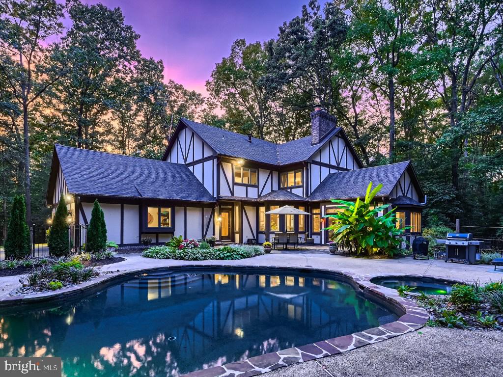 A grand Tudor sited aloft the most beautiful 2 acre arbored oasis. This Spacious 5 bedroom 5.5 bathroom estate offers both luxury and privacy for the most discerning of buyers. Rivaling a 5 star resort, this property features a stone waterfall adorned pool and gorgeous mature landscaping which together create the most serene and beautiful backdrop for relaxing or entertaining. Not to be outdone, the inside of the home features open rooms, a cathedral ceiling great room with stone fireplace, expansive kitchen island, cozy breakfast nook, an elegantly curved staircase AND climate controlled wine cellar. The Primary suite, with its inviting fireplace and ensuite floor plan, is an inviting space promising respite and repose. The formal living and dining rooms offer large spaces for the entertainer to shine. This is the ONE home that truly has it all.