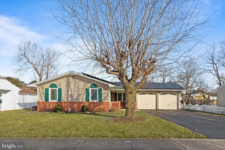 One-story living shines in this beautifully appointed three-bedroom, two-bath rambler, where generous spaces and thoughtful details come together effortlessly. A charming covered front porch welcomes you into a spacious, flowing floor plan designed for everyday comfort and easy living. The expansive living and dining area is anchored by a striking brick accent wall with a gas fireplace and raised hearth seating, creating a cozy yet dramatic focal point. This inviting space opens seamlessly to the kitchen, featuring granite countertops, lighted display cabinets, a pantry, and a breakfast bar that blends style with function. Just beyond, a large breakfast room offers the perfect spot for casual meals and morning coffee. At the rear of the home, a spectacular four-season sunroom, also serving as a family room, is wrapped in windows and overlooks the fully fenced backyard, creating a sun-filled retreat to enjoy year-round. The home is completed by two well-sized bedrooms served by a hall bath, along with a serene primary suite featuring an en-suite bath and a relaxing Jacuzzi tub. Crown molding and chair rail accents in most rooms add timeless architectural interest throughout the home. Outside, the property becomes a private oasis with a large entertaining pergola, a tranquil pond, and multiple storage options. A separate shed with a mini-split system provides flexible studio or workshop space, along with additional secured storage. Additional highlights include a two-car garage with interior access, main-level laundry and storage, a zoned irrigation system, fully fenced rear yard, leased solar and power bank system and recent updates including a new heat pump in 2024 and a new dishwasher in 2023. Comfortable, spacious, and impeccably cared for, this exceptional home offers easy one-level living with refined details and inviting indoor and outdoor spaces designed to be truly enjoyed.