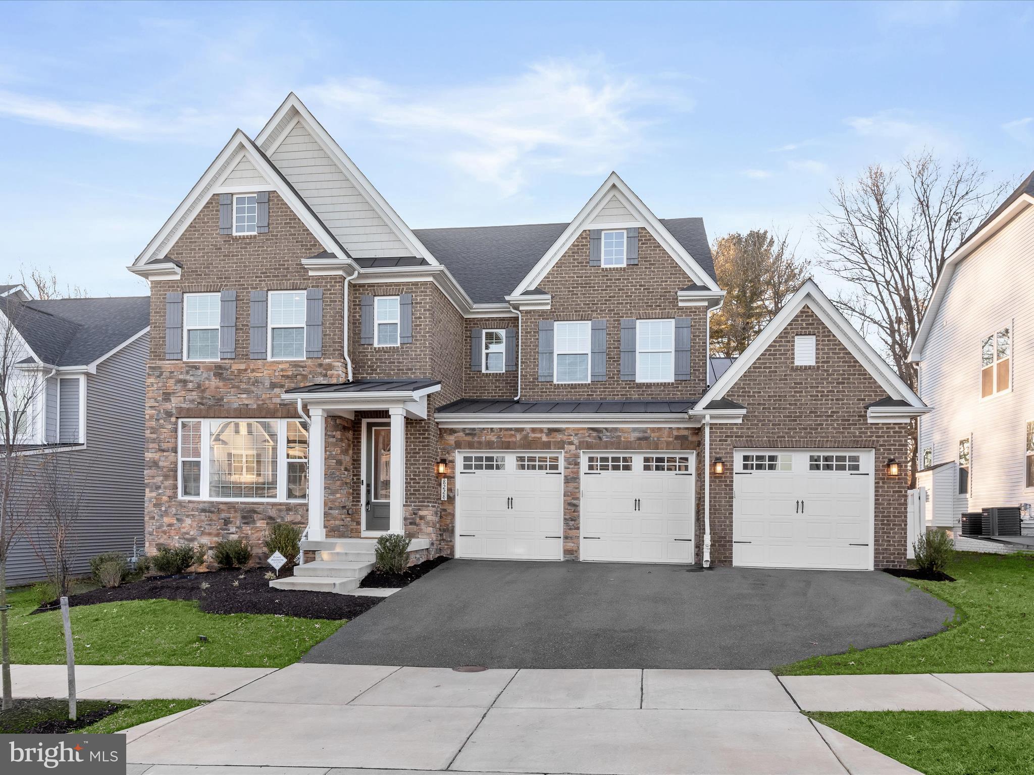Welcome home to 8228 Gunnar Drive in coveted Maple Lawn South! This exquisite luxury property is a premiere offering in this highly sought-after community. Built in 2021, this fully loaded Tyler Model boasts 5 bedrooms, 5.5 bathrooms and 5,648 total square feet of every upgrade imaginable. There are number of features that truly set this home apart: the rarely available main-level bedroom suite, 3-car garage, screened-in patio and fully fenced back yard. Both the main and upper levels feature wide-plank luxury vinyl plank flooring. The main level bedroom suite is thoughtfully finished with a large picture window, walk-in closet and its own full bathroom with shower. The private office, also on the main level, offers French doors, recessed lighting and two windows providing an abundance of natural light.
The open concept living and dining areas center around an inviting gas fireplace and make for the perfect places to entertain. The kitchen boasts every accoutrement desired by a gourmet chef and looks as magazine-worthy as it is functional. You’ll find shaker-style cabinetry with a contrasting island, a double oven, smart fridge, quartz countertops, under-cabinet lighting and an on-trend stainless steel farm sink. The spacious walk-in pantry and welcome center are conveniently located just off the entry from the 3-car garage providing the perfect family drop zone. The screened-in patio is a quiet retreat all its own and is found just off the eat-in kitchen area.
Upstairs, four more spacious bedrooms await connected by an expansive loft area at the upper level landing. The primary bedroom features trey ceilings, recessed lighting and two large walk-in closets. The primary bath can only be described as a spa-like retreat with its multi-head shower, jetted tub and separate quartz vanities. The secondary bedrooms feature either an en suite bath or buddy bath and the laundry room completes this level, conveniently located upstairs.
The luxe lower level of this home includes a spacious recreation room complete with recessed lights, a stone accent wall, and a built-in bar with all the bells and whistles: quartz countertops, a beverage fridge and a dishwasher. There is an additional full bathroom downstairs as well as an unfinished utility area for bonus storage space. With a fantastic community pool and gym and conveniently located close to major commuter routes and so many fantastic shops and restaurants, come see why the Maple Lawn communities are the premiere communities in Howard County. Hurry! 8228 Gunnar Drive won’t last long.