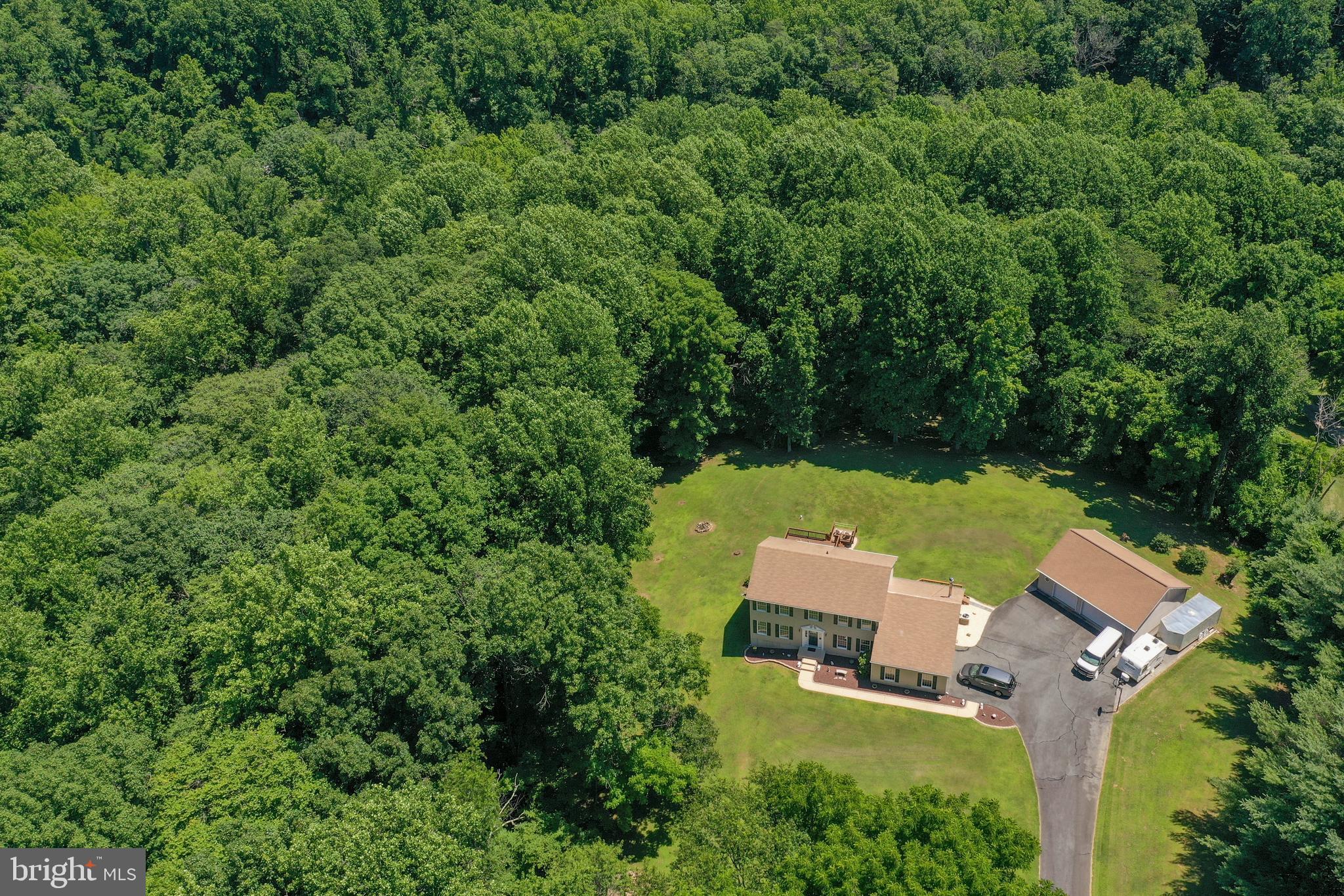 From the moment you enter through your private security gate, this 13.20 acre park-like retreat will offer you the peace and tranquility that you deserve. This one-of-kind gem offers privacy, freedom, and convenience. This mostly wooded property is studded with mature trees and has nature trails, abundant wildlife, running streams, and an overlook deck to take it all in. It's like having your own private park. There is no HOA and the property is zoned agricultural so your horses and farm animals are welcome. There are acres of meadows that would make great pastures, orchards, or vegetable gardens, with room for a possible future tenant's home. Bring your toys as there is ample parking inside and alongside the large attached two-car garage and the 28 x 36 detached three-car garage. There is also an additional 20 x 20 shed. You don't have to spend your life commuting, as this serene paradise is only 3.5 miles from the I-95 interchange in southern Harford County and is convenient to the I-95 business and employment corridor. The home is located in the Fallston school district. This 4 bedroom colonial boasts 3 ½ baths and an open floor plan with lots of closet space. The kitchen is equipped with stainless steel appliances, granite countertops, Schrock cherry cabinets, breakfast bar with separate large brunch area, and three pantries! The living room and den access the generous, main private deck. The family room has a modern free-standing woodstove for those cool evenings, or go outside to the spa and gaze at the stars in your very private retreat. A formal dining room rounds out the first floor. The master suite has crown molding, double vanity sinks, a walk-in closet, and two additional closets. The fourth bedroom can double as a sitting room or a nursery off of the master suite. The walk-out finished basement has ceramic floor, full bath, and kitchenette that could double as an in-law suite. This custom home was built with a precast concrete foundation with double drain tiles for an extremely dry basement. The home was constructed using steel beams, solid joists, Anderson high performance windows, Anderson sliders, Kohler cast iron tubs, and 2 x 6 exterior walls with extra insulation. The home is extremely energy efficient with the monthly BGE bill for the last twelve months average only $122.89! There are surveillance cameras and a hard wired security system installed. The property is bordered by Singer Road, Mountain Branch Stream, and Winters Run Road (and the parallel Winters Run Stream). Hike, bike, or ATV from your backyard on your many private trails to destinations such as Big Rock (the size of a small school bus), Mountain Branch Falls, or your own private picnic area. It is a short hike off of the property to Atkinson Dam and Harford Glen Park. The location of this home is convenient to everything including all of the big box stores, the hospital, and entertainment venues. There is a public boat ramp, marina, and yacht club only 5 miles away. You don't have to drive forever to the country to enjoy a country retreat.