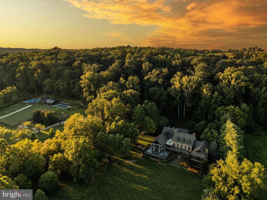Live Authentically, Telluride-inspired estate perched poetically on 13.38 rolling acres. Glorious panoramic vistas of sunflower fields and the Western Run Valley abound. Expansive and elemental. A robust mix of stone, steel, glass, and concrete. Hand forged raw steel staircase reminiscent of a mine shaft.  Create with a view… a dynamic cooking space overlooks massive, dramatic antique barn, a compelling great room. Artisan-level lighting.  Luxe theater. Elevator. Divine pool house, pool, pickleball court, putting green, and outdoor theater. Indoor Outdoor living taken to a whole new level. State-of-the-art solar field. Cultivate your existence. The art of uniting human and home.