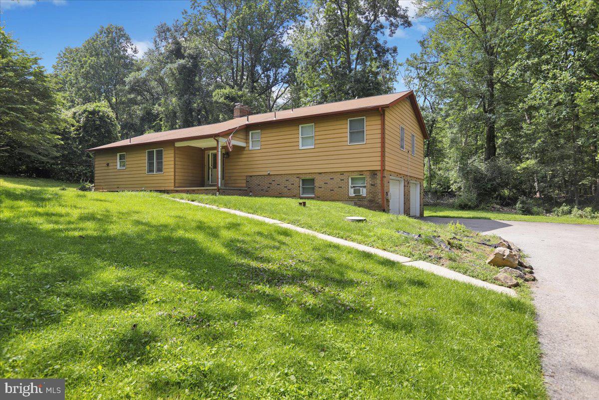 Nestled in a serene, tree-lined setting within the Antietam School District, this spacious 3-bedroom, 2.5-bath split-level home sits on a generous 1.07-acre lot. Enjoy outdoor living with a side patio and a deck, perfect for relaxing or entertaining.
The large eat-in kitchen features cherry wood cabinetry with 26 handles, stainless steel appliances, Pergo flooring, and tile countertops and backsplash. A convenient laundry room is located directly behind the kitchen for easy access.
The bright and inviting living/great room is anchored by a cozy wood-burning fireplace insert—one of two in the home. Upstairs, you'll find three comfortably sized, carpeted bedrooms. The main bedroom includes a private en-suite bath.
The lower-level family room offers additional living space with the second wood-burning fireplace insert, Pergo flooring, and a sliding glass door that opens directly to the yard. This level also provides access to the oversized two-car garage and a spacious storage area in the basement.