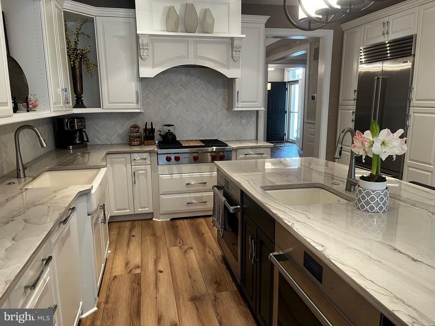 Stunning Fully Remodeled Townhome Backing to Wooded Preserve in Blue Bell

Welcome to this exceptional, completely remodeled townhome in the heart of Blue Bell, where luxury finishes, thoughtful design, and serene views come together seamlessly. Offering 4 bedrooms, 4 full bathrooms, and 1 powder room, this home has been meticulously upgraded throughout with no detail overlooked.

The gourmet kitchen is a true showpiece, featuring quartzite countertops, a tumbled marble backsplash, a striking stacked-stone island, a Wolf cooktop, dual Wolf wall ovens, and a Sub-Zero refrigerator—perfectly suited for both everyday living and entertaining. The kitchen flows effortlessly into the main living areas, enhanced by custom millwork and refined architectural details.

The family room is anchored by a dramatic stacked-stone fireplace wall, creating a warm yet sophisticated focal point. Custom millwork continues along the main stairway and powder room, elevating the home’s craftsmanship and character.

Upstairs, the luxurious primary suite offers a fully redesigned spa-like bath with a walk-in shower, quartz-topped vanities, and heated floors. The second full bath has also been completely renovated with upgraded tile, new vanities, and heated flooring, providing comfort and elegance for family or guests.

The lower level expands the living space and includes a beautifully appointed bar—ideal for entertaining, movie nights, or hosting gatherings including a full bath.

Enjoy abundant natural light from all-new windows throughout the home, including an Andersen picture window overlooking a tranquil wooded preserve. Step outside through the new door onto a newly constructed deck with a permanent roof and automatic screens, creating a private, year-round outdoor retreat.

This turnkey home offers the perfect blend of luxury, comfort, and natural beauty in a highly desirable Blue Bell location.