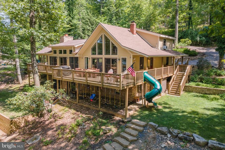 Welcome to 2411 Lake Shore Drive. This 5BR/4BA waterfront home with proven rental history boasts 352' of incredible, level waterfront with Type A dock which means nobody shares your dock, it's yours to enjoy all you own. Great lake views from most rooms, 3 massive native stone FP's, loads of glass and decking to enjoy the lake. This centrally located beautiful home has plenty of room on the inside and awesome exterior living spaces to enjoy all Deep Creek Lake has to offer. Outdoor fire pit for those relaxing evenings and lower level game room only add to the value. This home is NOT in Edgewater HOA BUT it is a member of the Edgewater Docks LLC. The Edgewater documents specifically guarantee this home a slip and via that DNR permit. 2 total slips convey with this sale: one with house via Edgewater dock LLC + one via Type A permit for 30 ft strip next door. Physical dock configuration subject to change. DNR will have final say but likely to remain unchanged. This is a true gem!