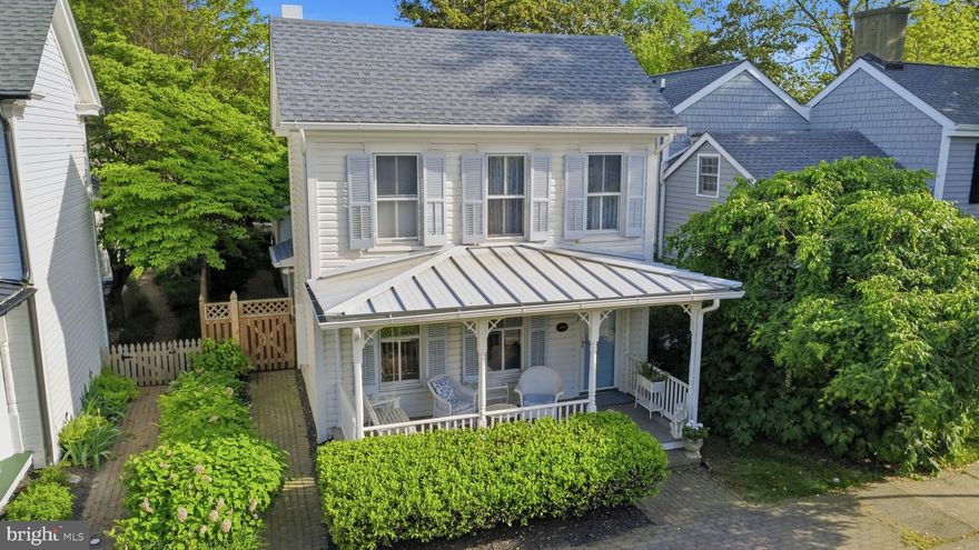 Known as the William J. Wrightson House, this distinguished circa 1897 residence in the heart of St. Michaels beautifully blends timeless elegance and refined architectural detail with the comforts and conveniences of modern living. Lovingly restored from top to bottom, the home has undergone extensive renovations and improvements, including all new HVAC systems, tankless hot water system, updated wiring, crawlspace encapsulation, new roof and gutters, recessed lighting, high-end appliances, three fully renovated baths, a custom butler’s pantry, complete interior and exterior painting, and new patio grading and drainage, among many others. A full list of improvements is available. Ideally situated just steps from the waterfront, marinas, boutique shops, waterfront dining, and renowned local restaurants, the property offers an exceptional in-town lifestyle in one of the Eastern Shore’s most beloved waterfront communities.
Filled with natural light throughout, the beautiful 3BR/3BA residence showcases heart pine and yellow pine flooring, custom millwork, and thoughtfully renovated living spaces designed for both everyday comfort and effortless entertaining. The welcoming living room, anchored by a new gas fireplace/stove, flows seamlessly into a gracious formal dining room ideal for gatherings with family and friends. The gourmet kitchen features quartz countertops, top-tier appliances, abundant cabinetry, and custom built-ins, effortlessly combining style and functionality.
At the rear of the home, a stunning sunroom addition serves as a true focal point, featuring vaulted ceilings, a shiplap accent wall, wet bar and custom butler’s pantry with beverage chiller and bar sink, custom built-ins, a renovated full bath, and French doors opening to the picturesque gardens and brick patio beyond. Upstairs, the comfortable primary suite offers a peaceful retreat, complemented by a luxurious bath with a clawfoot soaking tub, Carrara Bella marble flooring (in shower as well), custom antique vanity, and glass-enclosed walk-in shower. Two additional guest bedrooms and a beautifully renovated bath with marble tile flooring, granite-topped vanity, and Perrin & Rowe fixtures provide inviting accommodations for family and guests.
The outdoor spaces are equally enchanting, highlighted by a stunning English garden filled with roses, crepe myrtles, and hydrangeas, all enclosed by a charming French Gothic lattice shadowbox fence, creating a private and storybook setting.