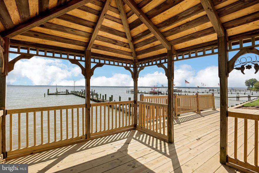 This wonderful riverfront home offers stunning views of the Potomac River and provides great spaces to enjoy the exceptional Southern Maryland waterfront lifestyle. The inviting entry to the home draws you immediately to water views from all rooms on the water side of the home with a fabulous staircase that is a focal point to the two story foyer and spacious living room with wood floors, filled with beautiful natural light. A nicely appointed kitchen with gas cooking, double ovens and abundant cabinetry and counterspace with a large island (over 20 feet seating space), opens to multiple dining spaces and a seating area with a fireplace, creating excellent entertaining space allowing all to enjoy the view of the water. The primary bedroom suite is a relaxing sanctuary where you can wake to the amazing water views. Enjoy coffee from your private balcony overlooking the water. Work from home has never been better from the flex room, which could also be a third bedroom or sitting room, that is part of the suite space. There is an additional bedroom with ensuite bath as well for guests. Outdoor living is at its best with multiple patios and a waterside gazebo. A three car garage is a sought after feature, a great place to store vehicles and water toys. Watermen will enjoy the pier and boat lifts, with recent improvements to the bulkheading and gazebo – the pier and lifts are “as is”. The HVAC and roof are also recent. What a perfect getaway that is about an hour to the DC beltway and convenient to many area attractions – the lifestyle is incomparable.