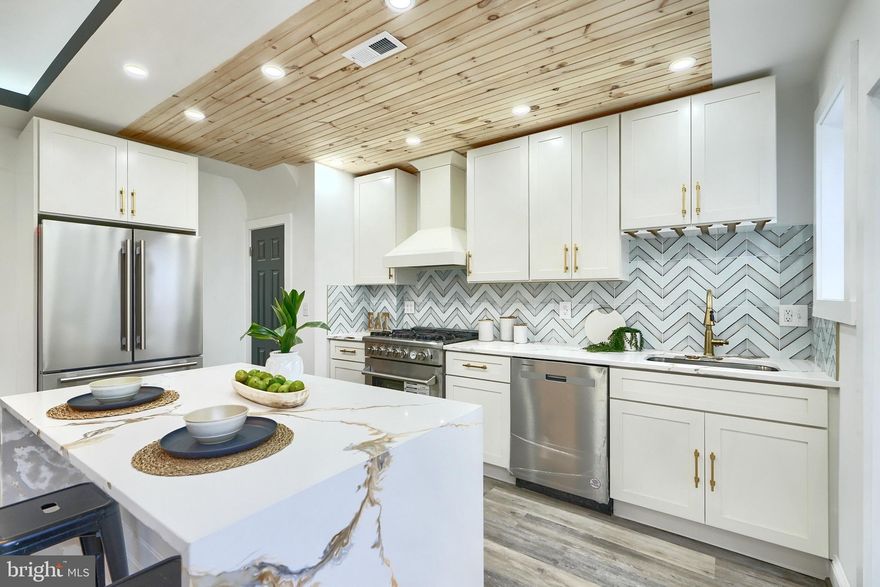 837 W 33rd Street has everything you can imagine in Hampden! Upstairs there are 3 bedrooms and 2 bathrooms, the main floor has a stunning kitchen with white cabinets, gold hardware, marble waterfall island, chevron backsplash, and a warm wood plank ceiling. The kitchen connects to the dining/living area that has large windows, tray ceilings, sleek lighting,  and a powder room. Off the kitchen you will enjoy a private pergola with stylish wood detailing, perfect for relaxing or hosting gatherings and you will love the concrete driveway. The basement is finished with a powder room, laundry area and large rec room. Come check out this house today!