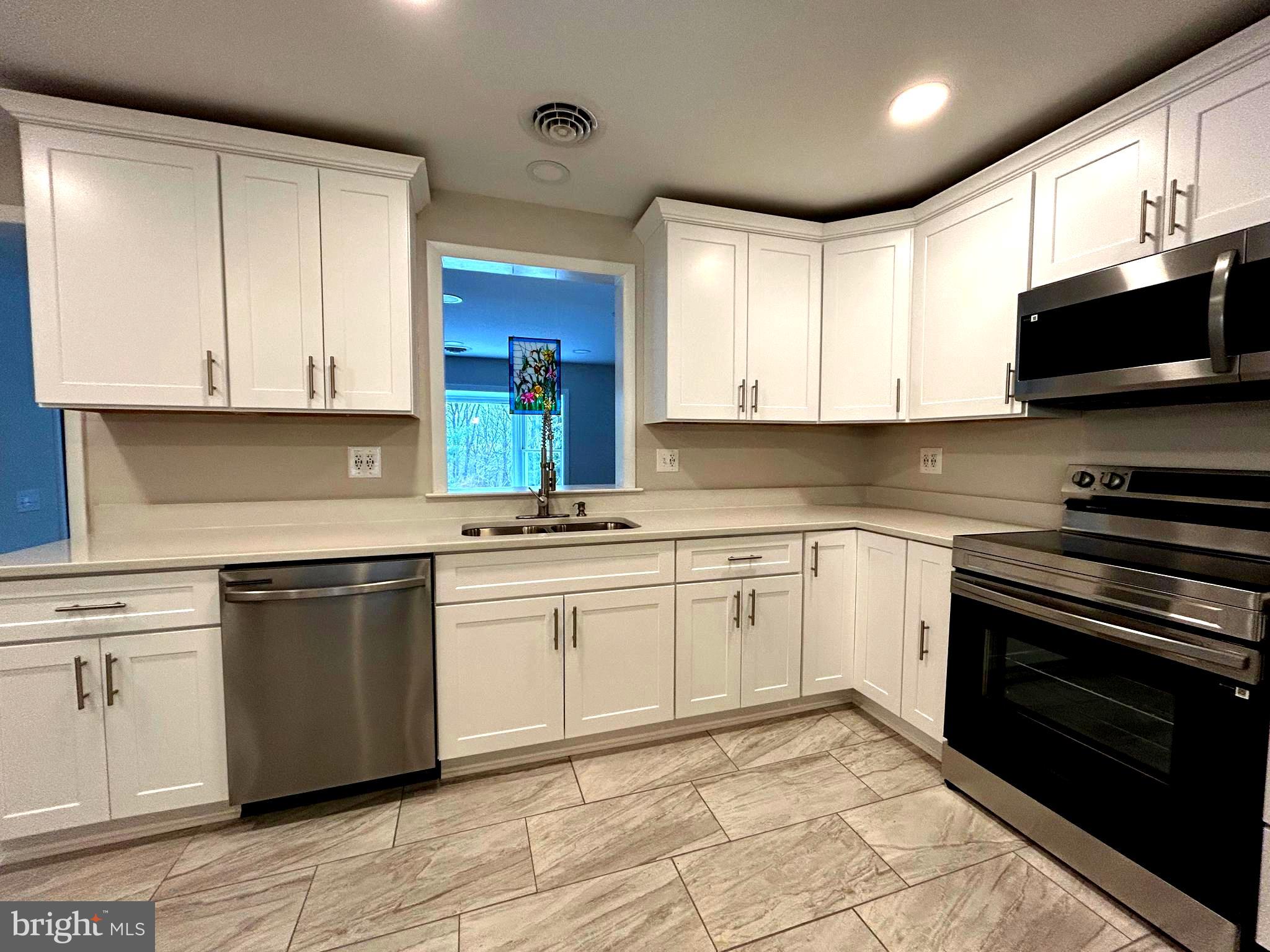 This is a completely remodeled house from top to bottom. Nothing left undone! New HVAC, new water heater, new well, new kitchen, new baths, new floors, new lighting incl 72 recessed lights, new carpeting, new everything!!!!! Gorgeous large kitchen done w SS appliances, quartz counters and high quality white cabinets w soft close doors and drawers. Beautiful ceramic tile floor and lots of recessed LED lights. Open window opening to addition and bay window beyond. Large peninsula w room for three kids and three pendant lights. A large living room w new hdwd floors, 12 recessed lights, a huge bay window and a stone fireplace. Separate dining room w rec lights and box and switch for future chandelier. A big addition w a family room and laundry. Family room has a very nice bay window w a very nice view as well as a door to the back yard. Laundry room is very large w room for lots of storage. Upper level has three good sized bedrooms w new lighting and new carpet. Both the hall bath and primary bath have been gutted and redone w top level finishes. The ground level has a very large recreation room off the foyer w a stone fireplace and new carpeting. There is an entrance door from driveway also. Basement level is fully finished w 12 recessed lights. A new water heater and new well pump and filtration are also in basement. Separate two car garage has lighting, electrical, two new garage doors and a line for gas, (not connected.) This house is ready to bring in furniture and live comfortably.