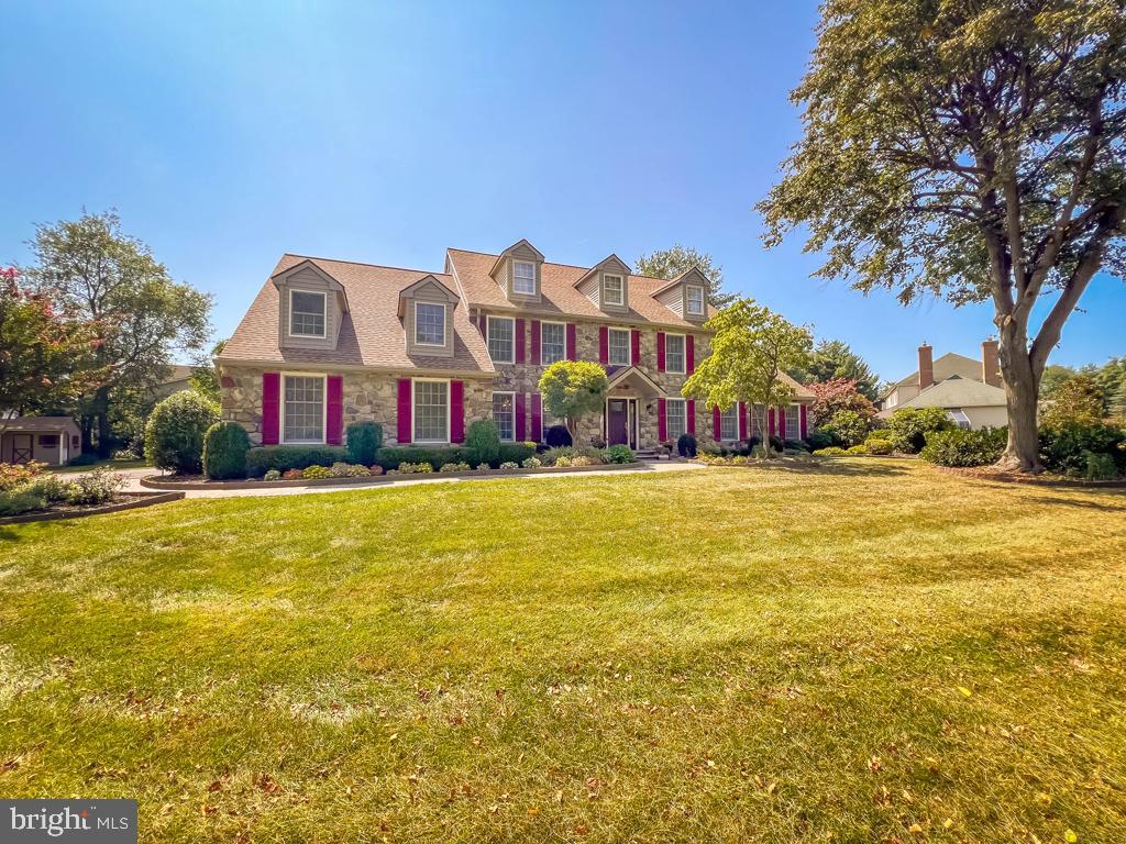This majestic estate sits proudly on a premium 1.5-acre lot in Newtown, tucked away at the end of a private, tree-lined driveway. Framed by a lush backdrop of mature trees and bursting with vibrant flowers and meticulously landscaped gardens, the property makes a breathtaking first impression. Inside, stunning upgrades and refined finishes create an atmosphere of timeless elegance. The dramatic two-story foyer showcases a sweeping turned staircase, while the center hall design gracefully separates the formal dining room from the sophisticated living room—perfect for both intimate gatherings and grand celebrations. The recently renovated gourmet kitchen is a true showpiece, boasting gleaming quartzite countertops, custom 42-inch cabinetry, a coordinated subway tile backsplash, and high-end stainless steel appliances. The oversized island takes center stage, offering both style and functionality. Just beyond, a spacious breakfast area with a cozy brick-surround fireplace sets the tone for warm, relaxed mornings. The sun-filled family room features an expansive wall of windows overlooking the serene backyard, filling the space with natural light. The wet bar adds a lovely social touch. A two-sided fireplace seamlessly connects the family room to the spectacular sunroom—a warm and inviting retreat, perfect for unwinding with a book, watching a game, or enjoying card night with friends. The main level also features an updated powder room, a well-appointed laundry room, and thoughtful architectural details throughout. Upstairs, the luxurious main suite offers a private office, an expansive walk-in closet, and a spa-like ensuite bath. Three additional generously sized bedrooms share a beautifully renovated hall bath with double sinks and abundant storage. The finished basement extends the living space with a media area, exercise room, play area, and a large storage room. Step outside onto the Cambridge paver patio and be surrounded by breathtaking landscaping—a peaceful haven perfect for relaxing or entertaining. This exceptional property offers an unmatched blend of privacy, beauty, and elegance. Available for an end-of-September closing.