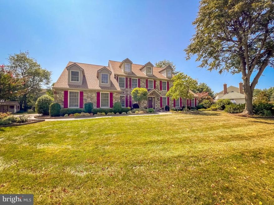 This majestic estate sits proudly on a premium 1.5-acre lot in Newtown, tucked away at the end of a private, tree-lined driveway. Framed by a lush backdrop of mature trees and bursting with vibrant flowers and meticulously landscaped gardens, the property makes a breathtaking first impression. Inside, stunning upgrades and refined finishes create an atmosphere of timeless elegance. The dramatic two-story foyer showcases a sweeping turned staircase, while the center hall design gracefully separates the formal dining room from the sophisticated living room—perfect for both intimate gatherings and grand celebrations. The recently renovated gourmet kitchen is a true showpiece, boasting gleaming quartzite countertops, custom 42-inch cabinetry, a coordinated subway tile backsplash, and high-end stainless steel appliances. The oversized island takes center stage, offering both style and functionality. Just beyond, a spacious breakfast area with a cozy brick-surround fireplace sets the tone for warm, relaxed mornings. The sun-filled family room features an expansive wall of windows overlooking the serene backyard, filling the space with natural light. The wet bar adds a lovely social touch. A two-sided fireplace seamlessly connects the family room to the spectacular sunroom—a warm and inviting retreat, perfect for unwinding with a book, watching a game, or enjoying card night with friends. The main level also features an updated powder room, a well-appointed laundry room, and thoughtful architectural details throughout. Upstairs, the luxurious main suite offers a private office, an expansive walk-in closet, and a spa-like ensuite bath. Three additional generously sized bedrooms share a beautifully renovated hall bath with double sinks and abundant storage. The finished basement extends the living space with a media area, exercise room, play area, and a large storage room. Step outside onto the Cambridge paver patio and be surrounded by breathtaking landscaping—a peaceful haven perfect for relaxing or entertaining. This exceptional property offers an unmatched blend of privacy, beauty, and elegance. Available for an end-of-September closing.