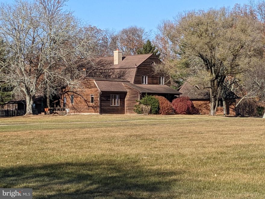 Beautiful sunsets are just one highlight of this impressive home set at the end of a long driveway on 10+ acres. From the front door you are immediately aware of the special design - starting with a large, open Living Room with two-story stone fireplace and exposed beams, and the separate brick fireplace that warms the kitchen and dining area. Oak floors run throughout the first floor, which also includes a sun-filled dining room, a family room with sunken bar area, and an island kitchen with separate pantry area that leads to the garage. Completing this first floor is a separate au-pair/in-law suite area with full bath and walk-in closets. Perfect for guests who come for the weekend! Upstairs are three bedrooms, two full baths, and ample closet storage. The outside is a private haven; there is a large deck with westward views of the setting sun, and a private pool with separate pool-house complete with full bath. Current owners have boarded horses nearby and love to ride on the open, flat acreage.  This is an ideal home for full time living or as a weekend retreat.