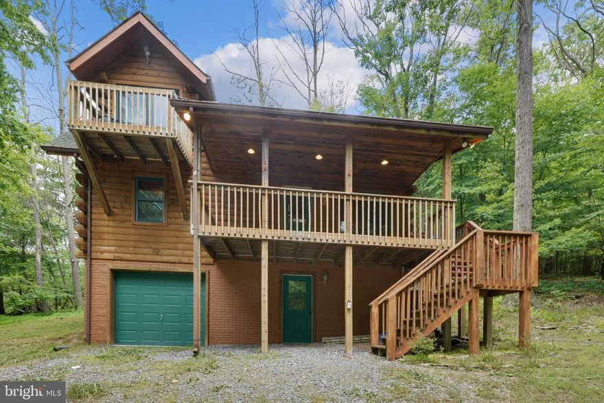 Social distancing at it's finest!  Check out this rustic, 6.78 acre, LOG CABIN in the WOODS located in the Catoctin Mountains in Thurmont, Maryland.  This gorgeous, rarely used, newly renovated, furnished, 3 level, 2 bedroom, 2 bath, custom Timberhaven Log Home has had a long list of costly renovations!   The main level of this home offers an open floor plan with a soaring cathedral ceiling,  a new, massive stone fireplace in the living room, all new lighting, ceiling fan, new wood flooring and new furniture that fits perfectly in this well decorated home.  The updated kitchen has a new granite countertop, new GE stainless steel appliances and a fully equipped kitchen (dishes, silverware, pots and pans) just waiting for you and your guests.  The dining area has a glass door that leads to the deck in the back of the house that provides an outdoor space to enjoy.  The main level also has a guest bedroom with a log queen size bed, a renovated full-hall bathroom, with a travertine countertop, sliding tub door and new flooring, a laundry/mud room with a washer and dryer and a door that leads to secluded back yard.  The main level of this home has a nice covered front porch, which is a great place to sit and enjoy the view and watch the seasons change.  The upper level has a private master bedroom with a vaulted ceiling and a private balcony off of the bedroom with a beautiful view of the wooded 6+ acre lot.  The master bedroom also has new carpet, a huge walk-in closet,  a master bath with a new a travertine countertop, sliding shower doors, new lighting and new wood flooring.  The log king size bed is perfect for this rustic master bedroom.  The cozy loft on the upper level is a perfect spot to read a good book and overlook the picture perfect rustic living room!  This home is listed as a 2 bedroom home, but it actually sleeps 10 people.  The lower level (basement), has 3 sets of bunk beds, providing more beds, for more guests and also has a wood stove that has not been installed.  The one car garage on the lower level has interior access to the home and  a window, so it could be converted to another bedroom or additional living space.  The new long asphalt driveway has sensors and security cameras to notify you when someone is approaching the home.  This home even has a new HVAC system!  The sellers paid Timberhaven Log Homes $7,000+ to create plans to add a 3 car garage to the property.  The plans can be transferred to the new owner and are ready for permits.  This home is privately situated at the top of the Catoctin Mountains and is just minutes from Cunningham Falls State Park, Huntington Creek Lake, Camp David, restaurants, gas stations, grocery stores makes this an ideal location!   Cunningham Falls State Park is home to Maryland's highest cascading waterfall and has beautiful hiking and walking trails.  Huntington Creek Lake is a popular spot for boating, fishing and picnics and has a sandy beach for swimming.  Besides enjoying park and lake access, this property is located less than 30 minutes away from Ski Liberty for winter activities.  Utilize this as a 4 season mountain escape, or year-round home located in the top-rated Thurmont school district.   Call today to schedule a private showing!