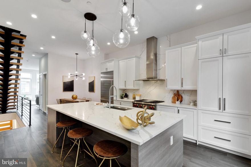 1220 Kater St is a stunning, like-new 3 bed, 3/2 bath townhome offering modern design, high-end finishes, and a tax abatement with 8 years remaining. Providing the best of city living, this +3,000 SqFt smart-home has 2-car garage parking, a private patio, and a roof deck, all in the heart of Philly's highly sought-after Bella Vista neighborhood. A quiet, low-traffic block leads to the home's front, where you're greeted by a contemporary blend of handsome brick and earthy wood. The style is continued inside the welcoming foyer with tile floors and reclaimed wood. From here, there's access to the two-car garage and a bonus space that's ideal for a home office or gym. The main level of the home is open and airy with soaring 11ft ceilings, rich, dark hardwood floors, and great natural light from tall northern and southern exposed windows. There's a large living room at the front and a coat closet, powder room, and dining area in the middle. At the rear, the spectacular chef's kitchen is adorned with 46" white shaker-style cabinets featuring pull-out shelves and soft-close doors, high-end stainless steel appliances, quartz counters and matching ceiling height backsplash, and a massive center island with seating for 4 and a wine fridge. Off the kitchen, the secluded rear patio, with its speakers, gas, and water hook-ups, has plenty of space to create a garden oasis, perfect for summer barbecues and al-fresco dining. On the home's second level, you'll find a guest suite and a bright bedroom at opposite ends, flanking a full bathroom and laundry room at the center. The home's third level is dedicated to the primary suite. There's a spacious, sunlit bedroom and a walk-in closet with lots of space to share. The huge, spa-like ensuite is fitted with an extra-long double vanity, hexagon tile floors that seamlessly extend into the dual-head rainfall shower, a soaking tub, and a water closet. Completing this level is a powder room and beverage center that services the home's expansive roof deck. With mesmerizing skyline views, tons of room to spread out, speakers, gas, and water hook-ups, this outdoor space is an entertainer's paradise! 1220 Kater St's smart-home features include Sonos speakers inside and out, heated tile floors, app-controlled security, climate, and lights, and a centralized vacuuming system. In addition to all that's inside, this fantastic home's equally fantastic location earns a Walk-Score of 99! Vibrant Bella Vista and neighboring Hawthorne are filled with friendly shops, cafes, and restaurants. Just around the corner, lively South Street is lined with local businesses, entertainment, and markets, including Whole Foods, Starbucks, and a veterinarian. Target, Sprouts Farmer's Market, and Wine & Spirit are nearby on Broad St, plus Hawthorne Park, Seger Park and Dog Run, and Palumbo Rec Center are a short walk. There's also easy access to Jefferson and Pennsylvania Hospitals, public transportation, and Washington Ave. Schedule your in-person or virtual tour today!