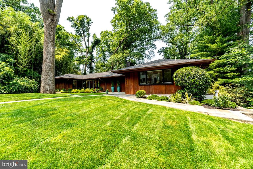 A Hidden Haven for Modern Living | Mid-Century Modern | 4BR | 3BA | Pool | 0.45 Acres

Some homes impress at first glance. Others reveal their magic slowly—and stay with you forever. 5116 Baltimore Ave is the latter. From the front, this Mid-Century Modern classic keeps a quiet profile: clean lines, original redwood siding, and a canopy of mature trees offer an elegant nod to its architectural roots. But step inside, and you’ll feel it—that unmistakable “wow” moment as light pours through expansive windows and the home unfolds into a stunning, secluded retreat.

Designed in 1948 by Diegert & Yerkes, the celebrated architects behind the National Arboretum, this home was featured in Better Homes & Gardens in 1954 for its graceful lines and visionary design. Today, it’s not just a beautiful home—it’s a sanctuary.

The main entry level is anchored by a sun-drenched living room with a gas fireplace and built-in bookshelves. The fully reimagined open-concept kitchen—featuring slate-toned cabinetry and stainless steel appliances—flows seamlessly into the dining and living areas, creating the natural heart of the home where meals, conversations, and everyday family life take shape. Sliding glass doors open to a tranquil side terrace, where al fresco dinners are the norm.

Two generously sized bedrooms, a full Porcelanosa bathroom with dual vanity, and a charming powder room complete this level—perfect for guests, family, or flexible living.

The garden level—fully above ground and seamlessly connected to the backyard—offers another spacious layer of living. At its center, an expansive family room with a real wood-burning fireplace and oversized picture windows invites movie nights, game days, or quiet mornings with coffee and the paper. Step directly onto the rear terrace and into a lush, private backyard bordered by mature trees, bamboo, and birdsong—your own personal retreat in the city.

The primary suite is a true sanctuary, complete with warm acoustic wood paneling, a built-in fireplace, floating nightstands with pendant lights, and a spa-inspired ensuite bath with oversized walk-in shower and dual Porcelanosa vanity. A second bedroom on this level is ideal for guests or creative space, with its own beautifully preserved full bath featuring rare red oak paneling and an elegant tub-shower combo. A laundry and storage room complete the floor.

Outside, the magic continues. With over 19,000 square feet across two legal plats, the backyard is an oasis—ideal for quiet reflection, lively gatherings, or full-on pool days with friends. The updated in-ground swimming pool is long enough for laps and framed by a spacious deck, lush landscaping, and a sense of total privacy. Whether you're sipping tea on the balcony or hosting a sunset dinner around the outdoor fireplace, this home elevates every moment.

Located in the desirable Westgate neighborhood—just over the DC line—the home offers easy access to Friendship Heights, Bethesda, and scenic trails along Little Falls Parkway. The community is filled with parks, playgrounds, and top-rated schools, making it as practical as it is beautiful.

Whether you restore, expand, or simply settle in, 5116 Baltimore Ave is more than a home—it’s a lifestyle, a legacy, and a place where every day feels a little more meaningful.