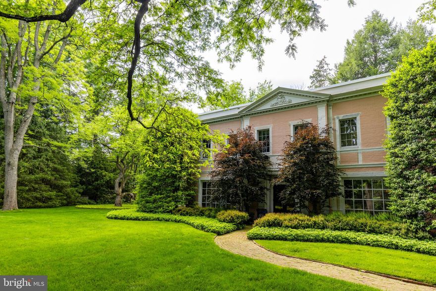 Discover Main Line magnificence in this secluded six-bedroom, seven-and-a-half-bathroom center-hall colonial featuring meticulously curated interiors, acres of arboretum-quality grounds and a coveted Bryn Mawr location. Available for the first time in 20 years, this exceptionally maintained residence awaits its next era of lavish entertaining and serene relaxation.
Originally designed and built by respected Main Line architect Walter K. Durham in 1935, this extraordinary home combines classic influence and prewar modernism to masterful effect. It's no surprise it has been professionally photographed and published in the pages of The Magazine Antiques.
A gorgeous brick façade with stone trim and a classic pediment underscores the home's classic inspiration. Inside the 7,180-square-foot showplace, ceilings soar over 10 feet tall above exquisite hardwood floors, handsome millwork, premium finishes and bespoke architectural details. The gracious foyer and grand staircase make a dramatic introduction to the classic center-hall layout with swag moldings and sophisticated wainscoting. To the left, greet guests in the regal formal living room featuring a stately stone fireplace, ornate crown molding and custom wall treatments. Here, French doors open to an inviting den with oversized windows, while a curved staircase leads to the main-floor owner's suite's sitting room and private quarters. The tranquil primary bedroom creates an ambiance of absolute serenity with luxurious wall-to-wall carpeting, custom wall coverings and a stately fireplace. Custom carved doors reveal multiple closets and  the vast dressing room, while the en suite full bathroom is a contemporary indoor-outdoor oasis where a freestanding soaking tub, two walk-in showers and separate vanities are surrounded by walls of windows.
To the right of the foyer, plan memorable gatherings in the large formal dining room warmed by a distinctive fireplace and topped by a soaring tray ceiling. Gracious entertaining is effortless, thanks to a powder room and direct access to the modern gourmet kitchen. Chefs will love the sleek wood cabinetry, large center island, stainless steel countertops and a fleet of professional-grade appliances, including a six-burner cooktop, Viking vent hood, double Wolf wall ovens, oversized cabinet-front refrigerator-freezers, and dishwasher drawers. Enjoy morning coffee and casual meals in the breakfast nook, where French doors lead to a stone patio. A large skylit mudroom does double duty as a pantry with walls of floor-to-ceiling cabinetry and shelving. A comfortable family room filled with French doors and a full bathroom completes the thoughtful main floor. 
Throughout the main level's indoor-outdoor layout, numerous French doors open to the park-like 2.37-acre grounds — a horticulturalist's wonderland of lush rolling lawns, specimen plantings, towering trees and manicured gardens. Retreat to the heated swimming pool, or plan al fresco dinners and garden parties on the large stone terraces.
Board your private elevator or ascend the elegant staircase to explore the home's second level, where the vast library invites you to curl up with a good book alongside carved built-ins and a fireplace. Four secondary suites with private baths provide plenty of room for friends, family and staff on this floor. Head to the lower level to find a carpeted home gym, an oversized laundry room and a wine room.
The special property sits very privately down a long lane leading to a stone motor court flanked by an attached two-car garage and a detached one-car garage. While it feels worlds away, this peaceful home is ideally situated near Main Line amenities, including wonderful shopping, fine dining, golf courses, train stations, and top-rated schools and colleges. Enjoy easy access to Center City Philadelphia attractions and the Philadelphia  Airport.