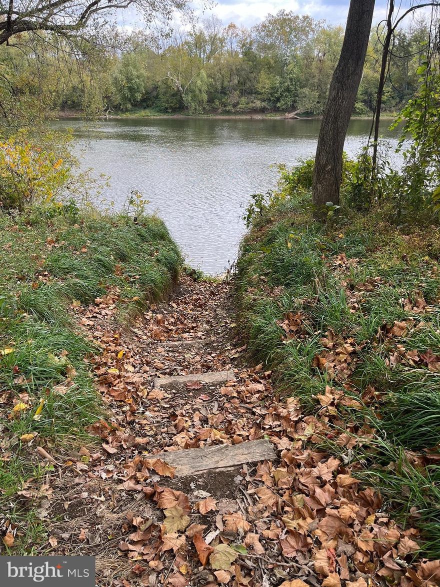 POTOMAC RIVER FRONTAGE This beautifully modified  lot is just a few yards from the public boat access, but this lot boasts its own access to the water front.  A walkway has been  cut out of the bank to create easy access to the water's edge. The lot has been filled, and a culvert added so that you can move about without the worry of mud and muck that often comes with hanging out at the river's edge.  The lot has a nice balance of grass and large trees to offer shade on the hot summer days, and an assortment of young fruit trees for potential future fruit. There are three 50amp camper hook-ups, and an underground storage tank for sewage that can be pumped as needed, along with the included porta-jon.  Two above ground water tanks and a portable electric pump to fill them are also there to round out your camping necessities.    A 10x24 shed complete with power, a full size fridge, a bar, and window AC unit, and a pellet stove to keep you warm and dry on those chilly or rainy days.   There is also a 12x20 car port to keep your outdoor toys and tools out of the weather.  The new owner will also find a 6x10 box trailer that conveys with the property that will come in handy for a multitude or uses.
There are two campers on the lot that will convey with the property. A 2019 30' Puma travel trailer, with 3 slide outs. Also conveying is a 2012 pop-up camper, complete with AC and mini fridge. There are kayaks, picnic tables, grills, fire pit rings, and a multitude of other camping necessities thrown into this sweetheart of a deal.  This lot is set up for anyone who wants to go camping,  but doesn't own a single thing needed to get started.  It's all here.