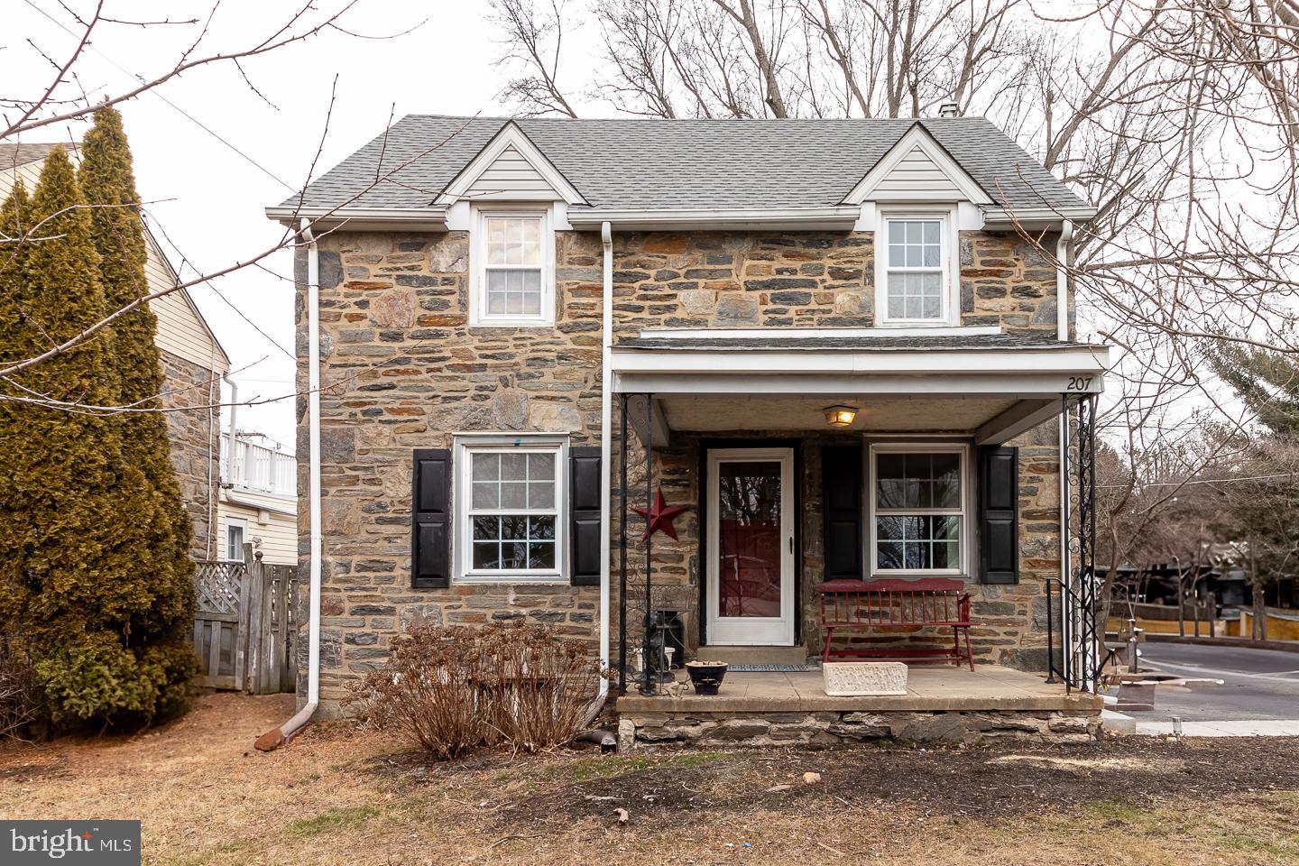 Welcome to this classic stone front single family Springfield home. Hardwood floors in Living Room, Dining Room and 3 upstairs bedrooms.  Brand new kitchen with LVP flooring, self closing cabinets, quartz countertops, new refrigerator, stove and dishwasher. Attached garage was converted to a bedroom with a full bath (stall shower). Good sized bedrooms upstairs, with walk in closets and ceiling fans. Stairs (steep) in one closet to attic for additional storage. Stacked washer dryer on first floor, sliding doors to deck and fenced in rear yard. 207 East Woodland Avenue has a Walk Score of 61 out of 100, so some errands can be accomplished on foot; it a two minute walk to the Woodland Av Station. Nearby parks include Spring Valley Park, Springfield Memorial Park and Jane Lownes Park.  Located in the highly desirable Springfield School District and close to shopping and major highways.