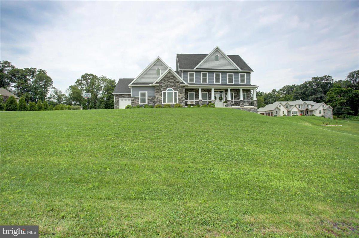 Welcome to 161 Lindman Drive – a stunning custom-built home situated on two picturesque acres in Chambersburg.
From the moment you step onto the large, covered front porch, this home impresses with timeless elegance and thoughtful design throughout. Inside, you'll find 9-foot ceilings on both the main and upper levels, creating an airy and expansive feel. Just off the foyer is a dedicated office with double glass French doors, offering a perfect work-from-home setup, and a powder room with tile flooring.
The formal dining room is open and elegant, featuring beautiful wainscoting and flowing directly into a truly custom kitchen—a dream for any chef. With quartz countertops, a commercial-grade six-burner gas stove with kettle faucet, a built-in microwave island with seating for four, and abundant cabinetry, the kitchen is a standout. Thoughtful storage solutions include built-in spice drawers, plate and pot drawers, display cabinets with lighting, under-cabinet lights, a built-in cutting board above the trash cabinet, USB outlets, three lazy Susans, and a dedicated appliance storage area.
A spacious laundry/mudroom sits just off the kitchen, complete with a sink, folding station, built-ins, and a cozy sitting nook. From there, access the private primary suite, which features double crown molding, French doors to the partially covered Trex deck, and a spacious walk-in closet with built-ins. The spa-inspired primary bath includes a tiled shower with side jets, a free-standing jetted tub, a large double vanity with generous cabinetry, and a private water closet with its own storage.
The main living area is open-concept, featuring 20-foot ceilings, a gas fireplace, and another set of French doors leading to the expansive Trex deck—perfect for indoor-outdoor living. A dark walnut hardwood staircase with wrought iron railing leads to the second floor, where you'll find four generously sized bedrooms, two full bathrooms (one with a double vanity), and a second living room. All bathrooms throughout the home are outfitted with Bluetooth speaker lighting, blending technology with convenience.
The walk-out basement is partially finished, offering a sixth bedroom, full bath with tub/shower combo, a third living area, and a quiet sitting space. The unfinished portion provides excellent storage and houses the home’s dual HVAC systems, two hot water heaters, dual 200-amp panels, and a water manifold system. Heating is provided by forced air fueled by buried propane tanks.
Enjoy year-round relaxation on the lower-level covered patio, complete with a hot tub and seating area. The three-car garage is fully drywalled and insulated, offering plenty of room for storage and projects. Recessed lighting is thoughtfully placed throughout the interior and exterior, including the covered front porch.
161 Lindman Drive is a remarkable blend of custom craftsmanship, functionality, and luxury—offering a private, peaceful setting just minutes from town.