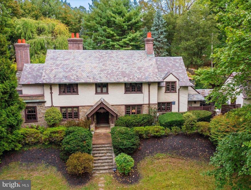 Nestled in the heart of Wayne, this Stately Tudor-style Colonial offers 4 bedrooms, 3.5 baths, and sits on a sprawling 1.4-acre lot—perfect for those seeking both space and the opportunity to add their personal touch. Upon entry, you're greeted by an inviting foyer that opens into a cozy living room, which transitions seamlessly into a bright and airy family room. This sun-drenched space, surrounded by large windows, custom built-ins, and elegant French doors, is bathed in natural light and complemented by a charming fireplace—ideal for both relaxation and entertaining. The sun-filled dining room, with its warm ambiance, sits adjacent to a wet bar/butler's pantry that leads into the kitchen, ready for your customization. Upstairs, the primary suite serves as a peaceful retreat, offering privacy and comfort, while three additional bedrooms and two baths provide generous accommodations for family or guests. For those seeking even more possibilities, the attic offers flexible space that can be transformed into a home office, additional bedroom, or creative studio. Outside, the property's exterior is just as impressive  with a detached garage that includes bonus space—ideal for a home office, gym, or extra storage—complete with its own powder room.  A fenced-in pool and patio area sit nearby, leading to a spacious play area that’s perfect for outdoor activities and entertaining. This unique property is ready for new owners to add their personal touch and make it their own. A rare find in such a desirable location—don’t miss out on this special opportunity!