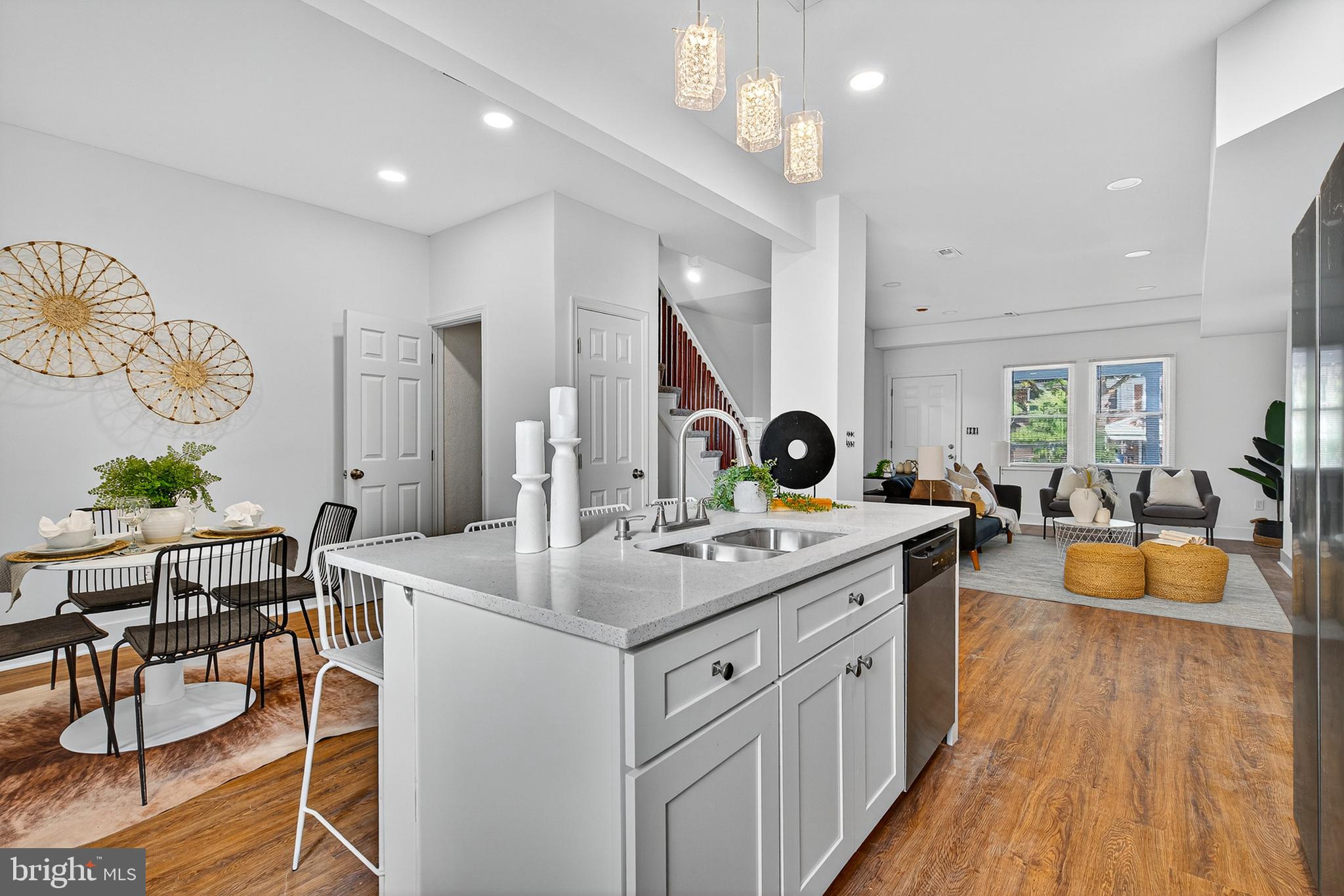 Welcome to this meticulously renovated row home, where the timeless appeal of classic brick architecture meets a brilliant, open-concept design defined by light, luxury finishes, and contemporary styling. This property delivers the perfect blend of neighborhood character and high-end, maintenance-free city living.
Step inside to discover a sun-drenched, flowing main level optimized for modern living. The space is anchored by gorgeous wood-look flooring and pristine white walls, creating a canvas of serene elegance.
The heart of the home is a stunning kitchen featuring crisp, white shaker cabinetry, brilliant white countertops with subtle quartz-like speckling, and a full suite of stainless steel appliances. A large central island with a deep stainless steel sink offers prep space and bar seating beneath chic pendant lighting, seamlessly connecting the cooking area to the dining and living spaces.
The adjacent living room provides a comfortable retreat centered around a sleek, modern electric fireplace framed by a clean white mantle. Thoughtful details, like the recessed lighting and the charming stairwell with painted risers and warm wood banisters, enhance the bright, airy atmosphere.
 A beautifully tucked-away powder room on the main level features an elegant vanity and modern fixtures.
The home’s upper floors continue the commitment to quality with soft, gray plush carpeting and expansive windows that bathe the bedrooms in natural light.
The spacious primary suite is a true sanctuary. The en-suite bathroom is a masterpiece of design, boasting marble-look tile, a glass-enclosed shower with a hex-tile floor, a modern vanity, and high-contrast brass-gold fixtures for a touch of refined glamour. A walk-in closet completes this desirable space.
The remaining bedrooms are bright, well-proportioned, and versatile, including an attic-level suite with architectural ceilings. The additional full bathrooms showcase consistent, high-quality renovations, featuring sleek vanities, striking marble-look tile, and contemporary matte black fixtures for a cohesive, modern aesthetic.
Enjoy private outdoor space with a rear entrance leading to a paved parking pad, offering the coveted convenience of off-street parking. An upper-level deck/balcony provides a perfect elevated spot for morning coffee or evening relaxation, overlooking the rear area.
This turnkey residence has been thoughtfully updated from top to bottom, offering an exceptional opportunity for a sophisticated buyer seeking style, comfort, and convenience.
Schedule your private viewing today!