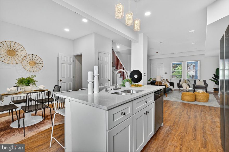 Welcome to this meticulously renovated row home, where the timeless appeal of classic brick architecture meets a brilliant, open-concept design defined by light, luxury finishes, and contemporary styling. This property delivers the perfect blend of neighborhood character and high-end, maintenance-free city living.
Step inside to discover a sun-drenched, flowing main level optimized for modern living. The space is anchored by gorgeous wood-look flooring and pristine white walls, creating a canvas of serene elegance.
The heart of the home is a stunning kitchen featuring crisp, white shaker cabinetry, brilliant white countertops with subtle quartz-like speckling, and a full suite of stainless steel appliances. A large central island with a deep stainless steel sink offers prep space and bar seating beneath chic pendant lighting, seamlessly connecting the cooking area to the dining and living spaces.
The adjacent living room provides a comfortable retreat centered around a sleek, modern electric fireplace framed by a clean white mantle. Thoughtful details, like the recessed lighting and the charming stairwell with painted risers and warm wood banisters, enhance the bright, airy atmosphere.
 A beautifully tucked-away powder room on the main level features an elegant vanity and modern fixtures.
The home’s upper floors continue the commitment to quality with soft, gray plush carpeting and expansive windows that bathe the bedrooms in natural light.
The spacious primary suite is a true sanctuary. The en-suite bathroom is a masterpiece of design, boasting marble-look tile, a glass-enclosed shower with a hex-tile floor, a modern vanity, and high-contrast brass-gold fixtures for a touch of refined glamour. A walk-in closet completes this desirable space.
The remaining bedrooms are bright, well-proportioned, and versatile, including an attic-level suite with architectural ceilings. The additional full bathrooms showcase consistent, high-quality renovations, featuring sleek vanities, striking marble-look tile, and contemporary matte black fixtures for a cohesive, modern aesthetic.
Enjoy private outdoor space with a rear entrance leading to a paved parking pad, offering the coveted convenience of off-street parking. An upper-level deck/balcony provides a perfect elevated spot for morning coffee or evening relaxation, overlooking the rear area.
This turnkey residence has been thoughtfully updated from top to bottom, offering an exceptional opportunity for a sophisticated buyer seeking style, comfort, and convenience.
Schedule your private viewing today!