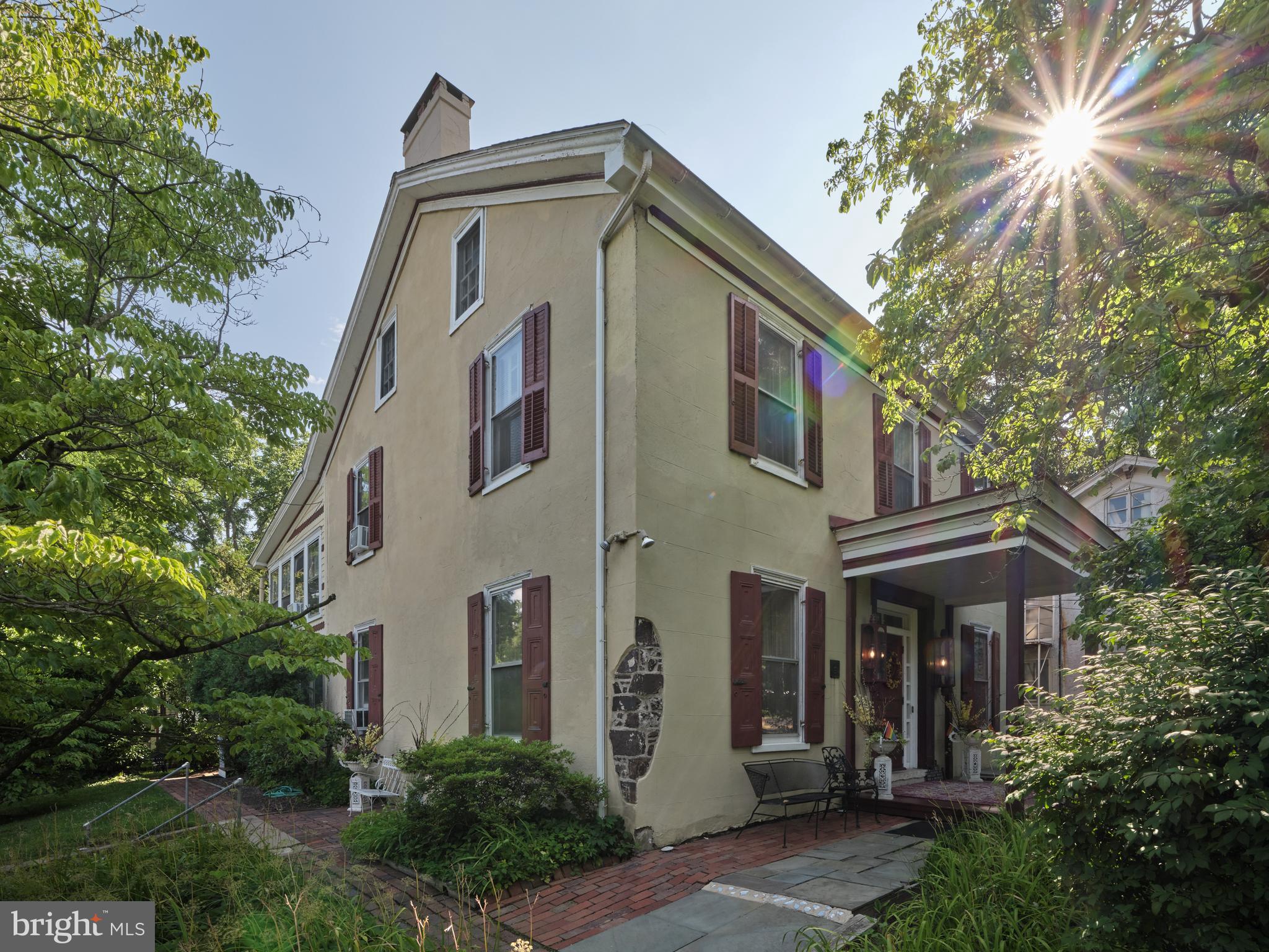In the heart of New Hope’s historic district is the Umpleby House, a Classic Revival plaster over stone manor house built in 1833 and a delightful one bedroom, one bath two story carriage house on the same property. Currently a luxury Bed and Breakfast, this approximately 4800 square foot manor could also make a wonderful home for the discerning buyer who desires the artisan craftsmanship of an historic property along with the amenities of the twenty-first century, and a separate building for guests or in-laws and all on a large, landscaped lot in one of the best locations in New Hope. Named as one of “America’s Favorite Towns” by Travel and Leisure magazine, New Hope Pennsylvania is a beautiful village with a long and storied history. Located just an hour from Philadelphia, 90 minutes to NYC and half an hour from Princeton, New Hope is a wonderful location for those that like the convenience of being able to walk into a bustling hub of shopping, restaurants and galleries but retain the relaxing feel of village life. The Umpleby House, named after William Umpleby, a local mill owner, is an elegantly refined building built on a pre-war foundation and served as headquarters for General Washington’s Army for six years. A Victorian-era addition was added to the rear in the late 1880s by owner Colonel Buckley. The current owners purchased and renovated Umpleby House in 1985, converting it to the 8 suite upscale, luxury inn that it is now. They also added the fanciful three-tier Victorian porches in 2001. A classic front entry provides a visual memory of the buildings original use as a single family home. A long center hall and grand staircase is currently flanked by a beautiful guest suite to the right and a formal living room with fireplace on the left. All of the historic craftmanship is evident, 9’ ceilings, deep handcrafted moldings, random width hardwood floors, refitted antique lighting fixtures, tall double hung windows with deep window wells, the historic detail that will be retained in the rediscovery of the homes original purpose. Main floor guest suites can become living and dining rooms again. The suites on the second floor can become luxurious bedroom suites, some with private entrances and balconies, freestanding gas or electric fireplaces and the third floor could become a fabulous primary bedroom suite. A 550SF caretaker’s apartment in the basement might be the perfect place for a nanny, au pair or recreation room. The large country kitchen is ready for all of the future celebrations that will take place here. If multi-generational use is needed what better place than the Carriage House? Just a few steps away, overlooking the lush lawn and landscaping, the two story Carriage House features a main floor living area with woodstove and a full bath and a second floor bedroom with large covered porch. One can easily imagine an expanded kitchen area so that Mom and Dad can have privacy but still be close by. An attractive two car detached barn/garage completes the property. There are precious few opportunities in New Hope to have this kind of history, space, amenities, large lot, plenty of parking and all in the best location. The Umpleby House is waiting for the vision of its next stewards to take it from its current life as an elegant inn to a future as a single family home.