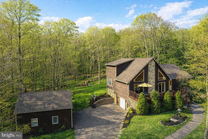 Discover the perfect blend of rustic charm and modern comfort in this inviting turnkey 3‑bedroom mountaintop chalet with lake access, set on 1.17 private acres with expansive outdoor entertainment space. Whether you're hosting friends or enjoying quiet mountain evenings, this fully-furnished home delivers an unforgettable retreat. Inside, the great room impresses with a soaring stacked‑stone fireplace. The primary bedroom features vaulted ceilings, giving the space an airy, elevated feel. The lower level is built for entertainment, complete with a billiards table, a full bar, and a projector‑screen TV—ideal for movie nights, game days, or hosting friends. This level also includes a basement‑level garage, providing convenient storage and easy access. Outdoors, the property truly shines. The expansive backyard offers multiple areas to relax and entertain, and the detached shed‑garage has been converted into an additional outdoor entertainment space, perfect for gatherings, hobbies, or simply enjoying the mountain air. A new whole house generator allows for peace of mind during those Mountain Maryland snow storms! As part of the Mountainside community, residents enjoy access to tennis courts, basketball courts, and a lakefront clubhouse, adding even more ways to unwind and stay active. This chalet delivers the full mountain‑living experience—privacy, comfort, and endless entertainment options in a beautifully wooded setting. Call now for more details or to schedule your private tour!