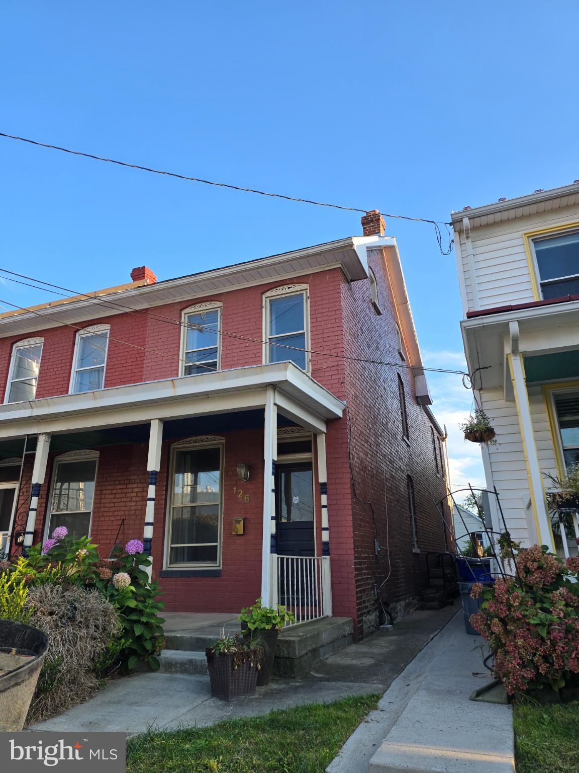 This charming end-of-row/Duplex townhouse, originally built in 1918, offers a perfect blend of historic character and downtown convenience. Step inside to discover a warm and inviting interior featuring traditional wood floors, a cozy brick fireplace, paired with the comfort of HVAC. The country-style kitchen, complete with ample table space, is perfect for casual meals, while the dining area invites memorable gatherings with loved ones. Upstairs, you'll find three bedrooms, one with and adjoining finished attic and a spacious full bathroom with a claw foot soaking tub! There is also a balcony overlooking the back yard for relaxing, reading, sipping...The partially finished basement provides additional flex space, half bath, laundry room and storage, with convenient outside access. Outside, enjoy the lovely rear yard, ideal for gardening, fire pit or playing with friends and family. This all brick home is located in the vibrant Frederick downtown, and is just a short distance from public transportation options, including bus stops and a commuter rail station, making commuting a breeze. The neighborhood boasts a strong sense of community, with nearby parks and local amenities that enhance the quality of life. Excellent schools and public services further enrich this desirable location, making it a wonderful place to call home. With off-street parking for two vehicles, convenience is at your doorstep. Embrace the comfort and charm of this delightful property, add your personal touches and TLC to make this HOME!